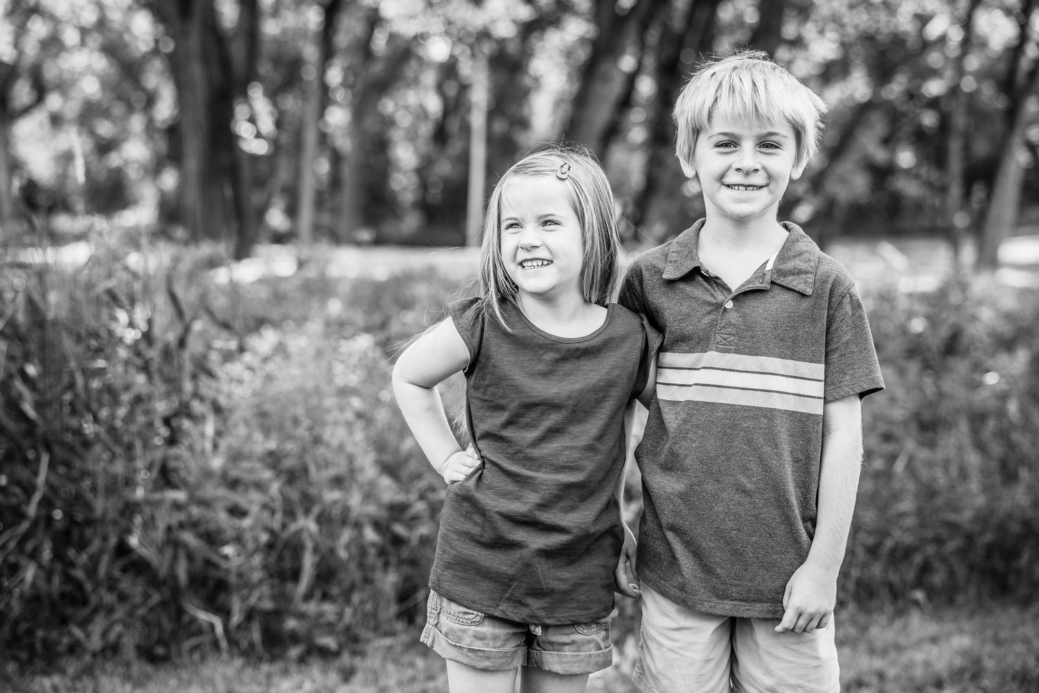 Children playing together in a park setting captured in black and white.
