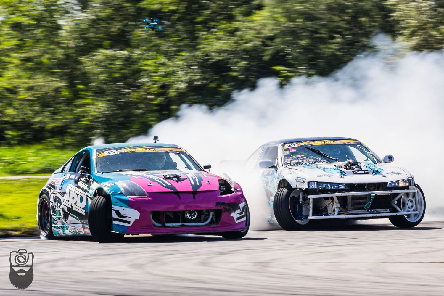 Colorful drift cars sliding sideways on a race track with smoke trails.