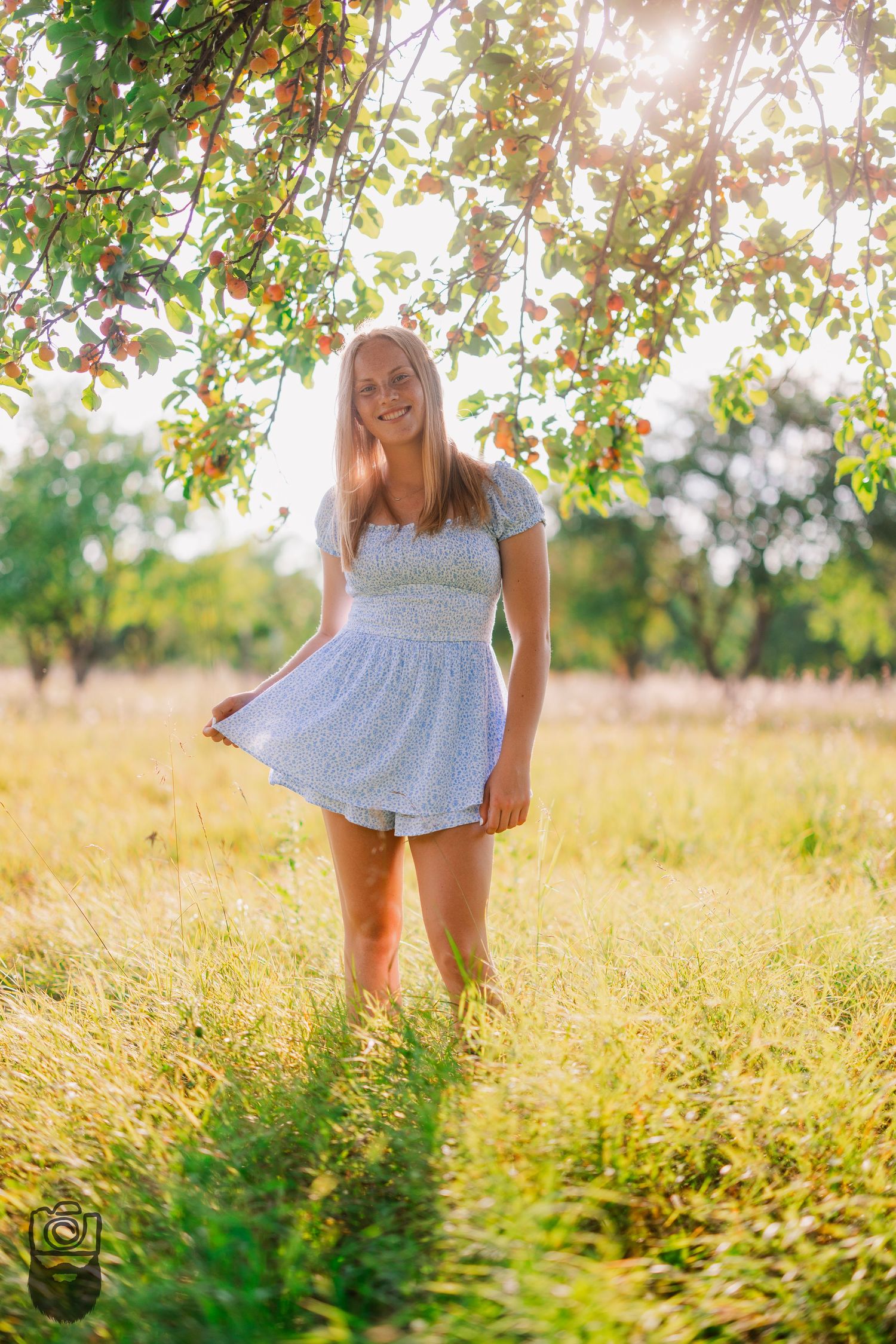 Blue dress twirls in a sun-drenched meadow during golden hour.