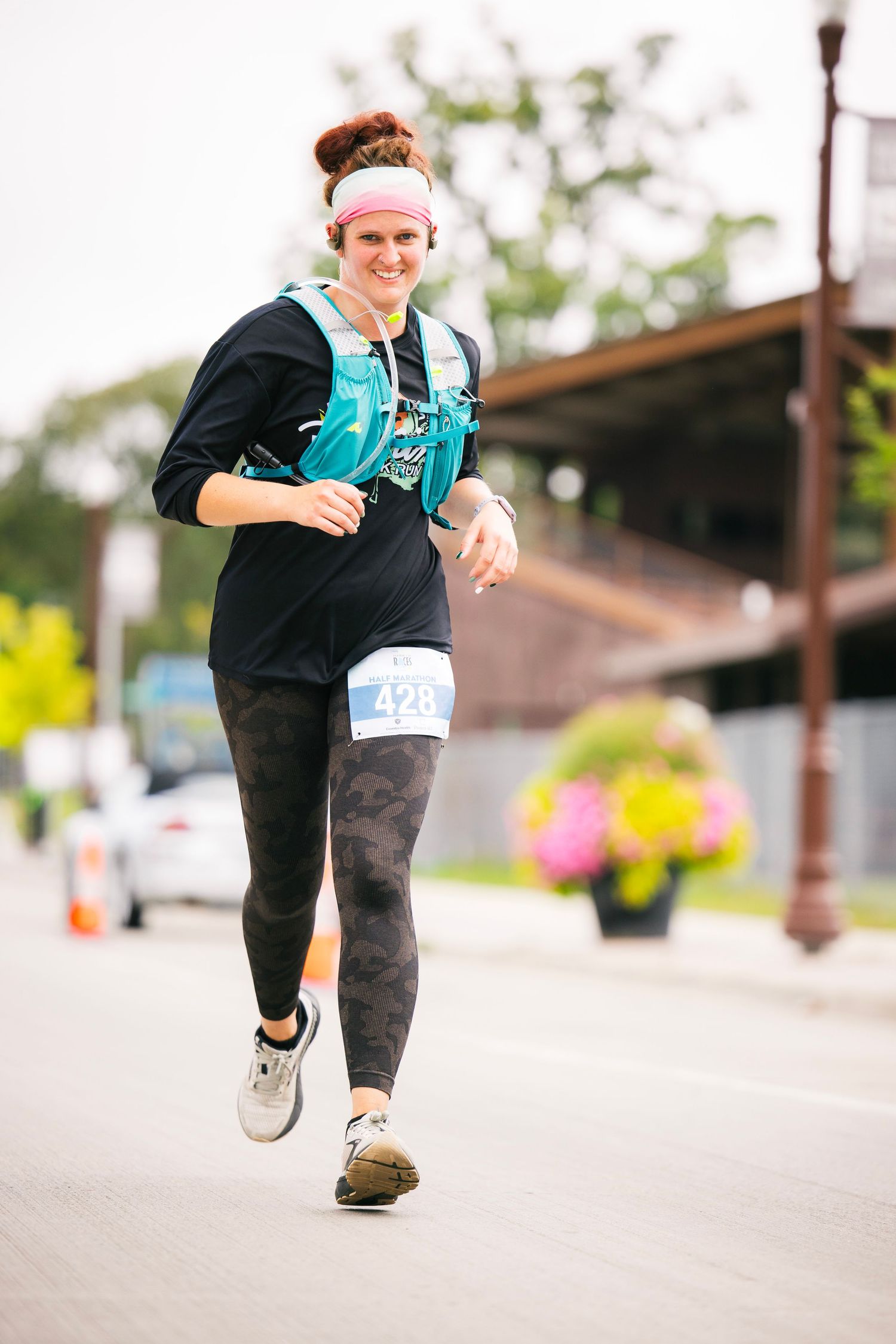 Runner in black athletic wear moving along outdoor path during race.