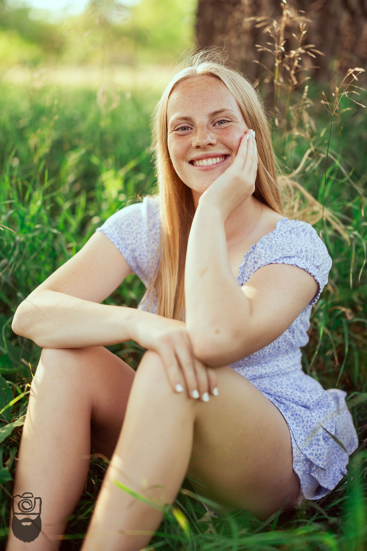 Summer portrait in grass with soft natural lighting and white floral dress.