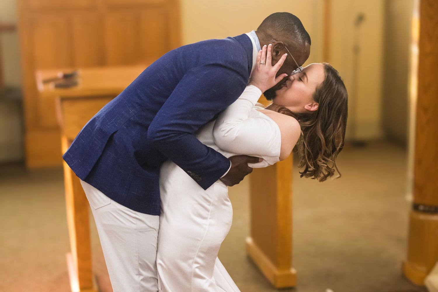 A sequence of romantic dance poses between a couple in formal attire inside a wooden-pillared venue.
