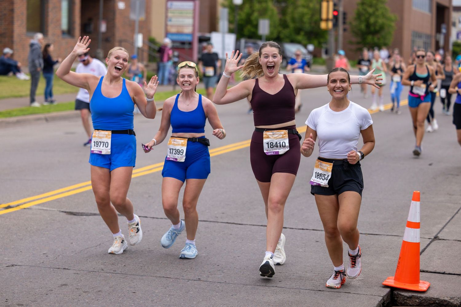 Participants running around orange traffic cones during community race event.
