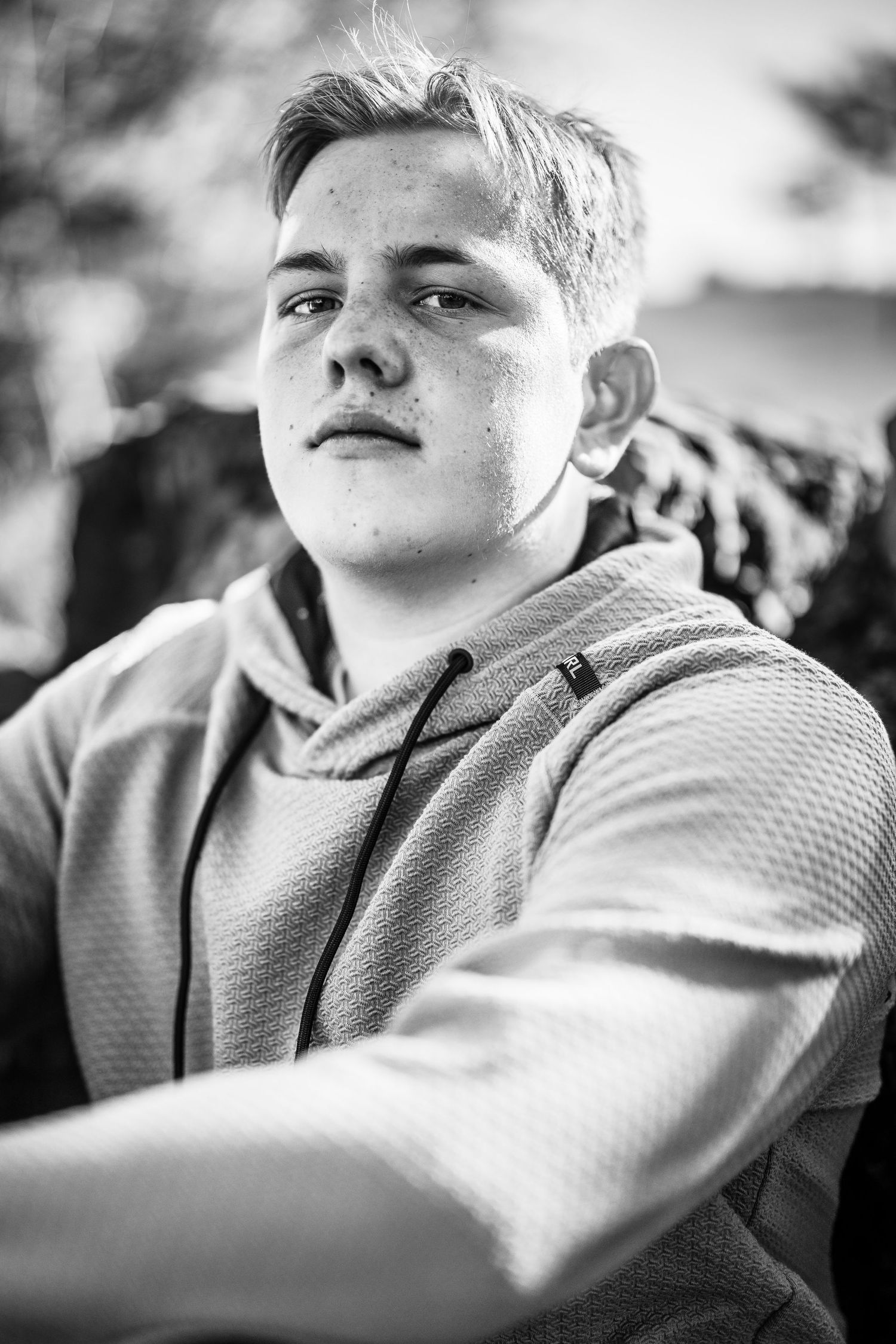 Black and white close-up portrait showing textured sweater detail.