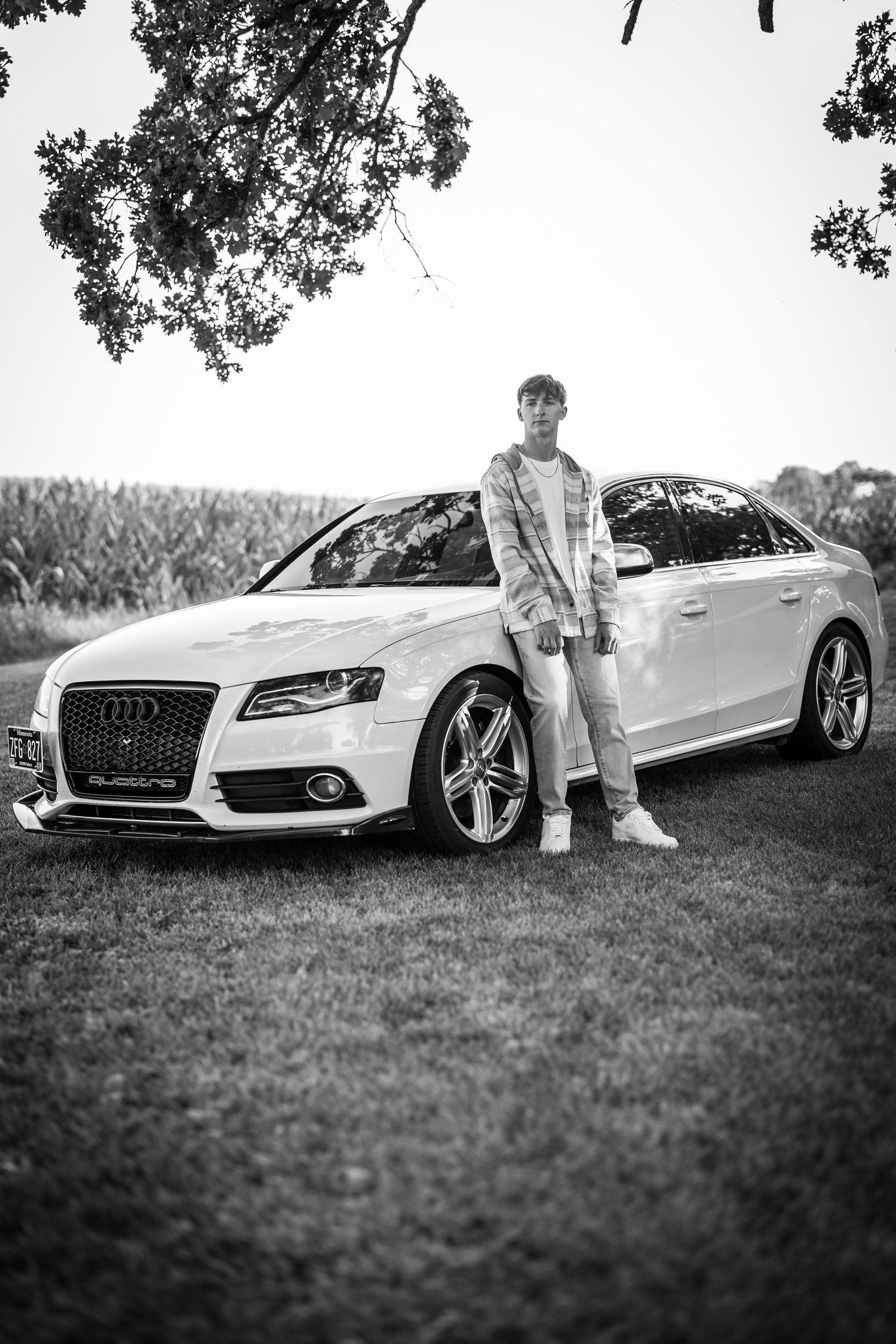 A white Audi sports car sits on grass in a black and white photograph.