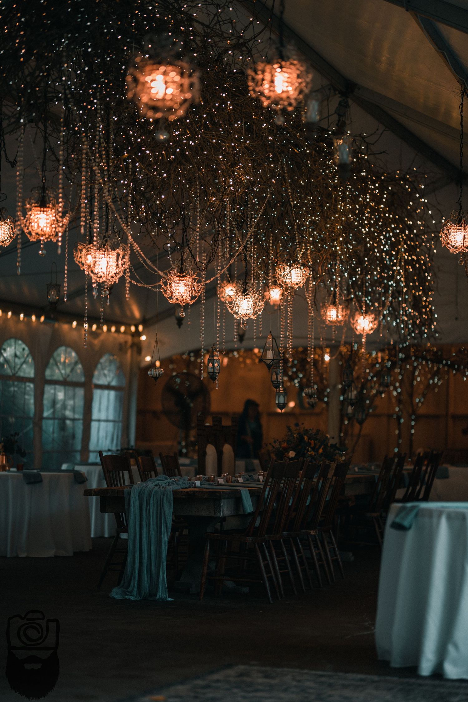 Elegant reception hall decorated with hanging chandeliers and twinkling fairy lights.