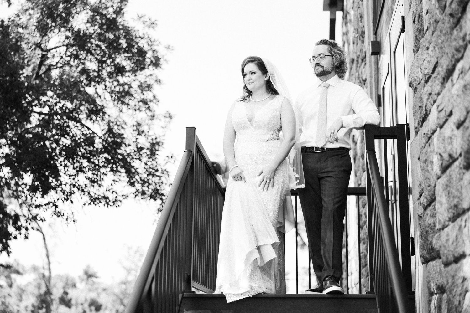 Artistic black and white wedding portraits taken against stone architecture.