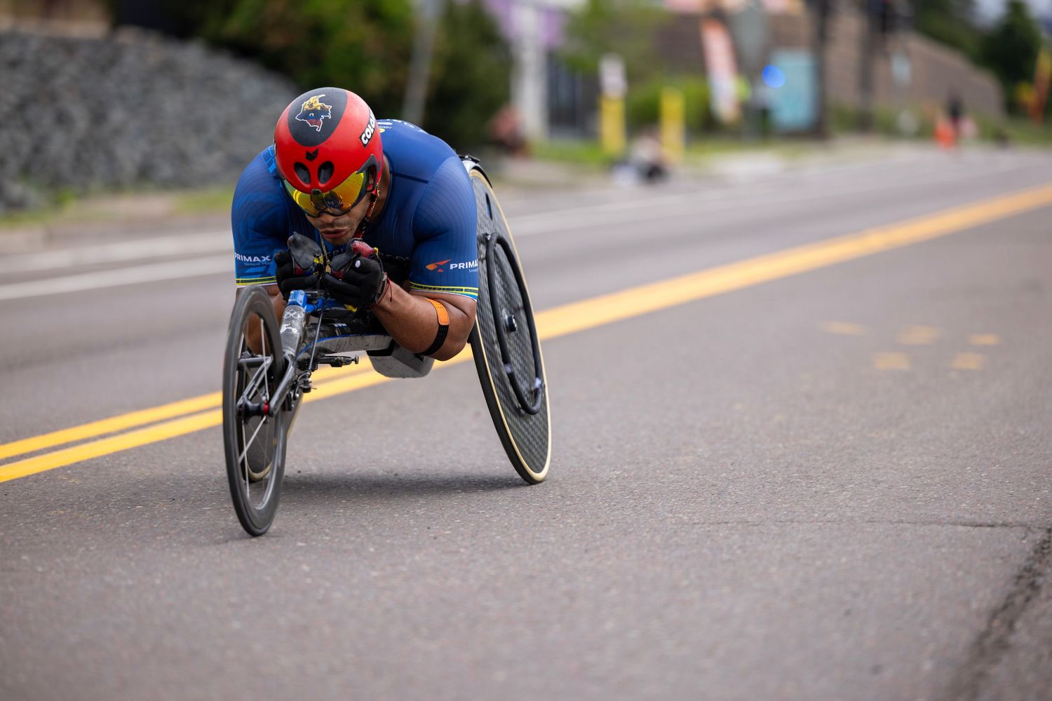 Wheelchair athletes racing down street during competitive event.