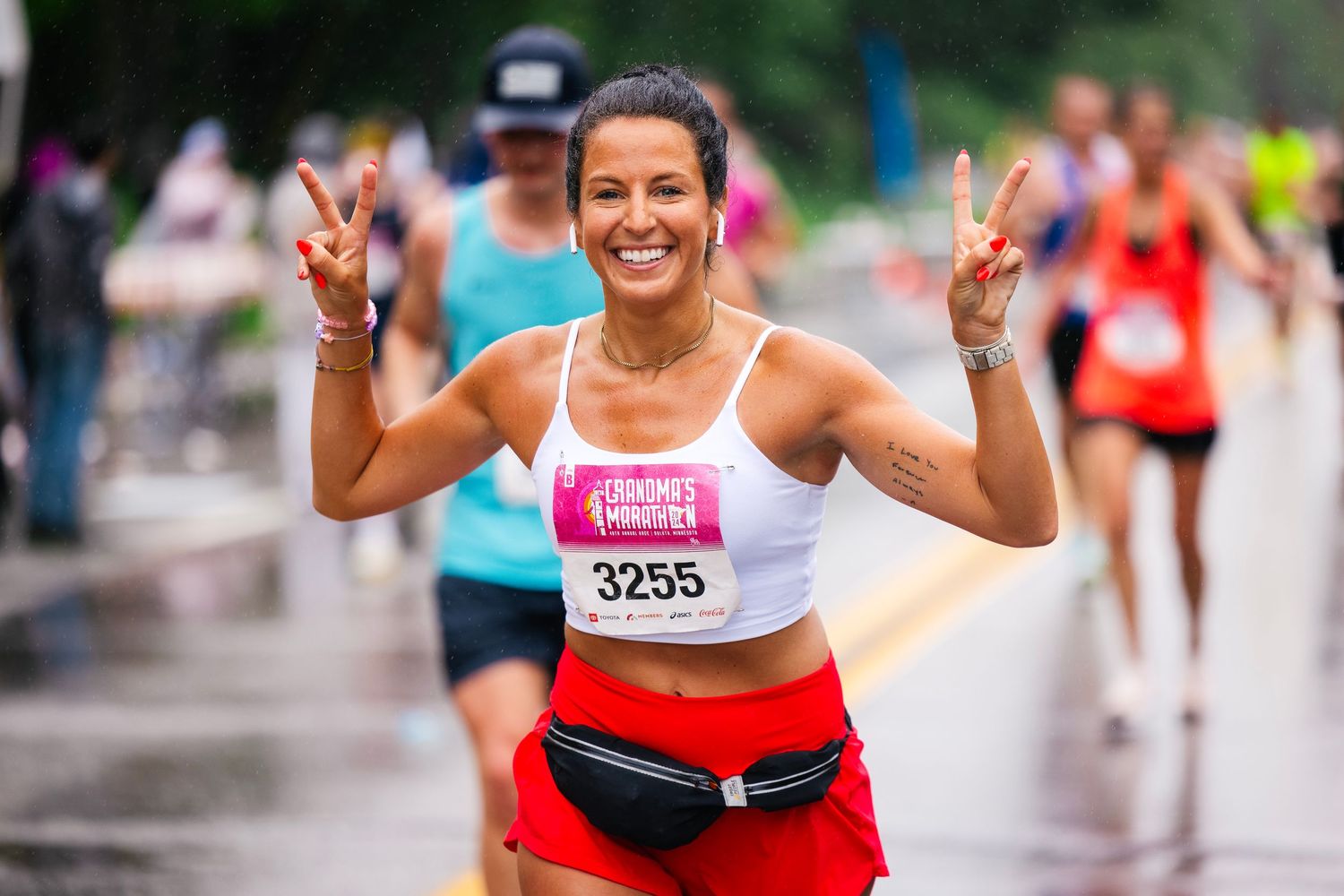 Athletes celebrating during a marathon race wearing race bibs and athletic gear.