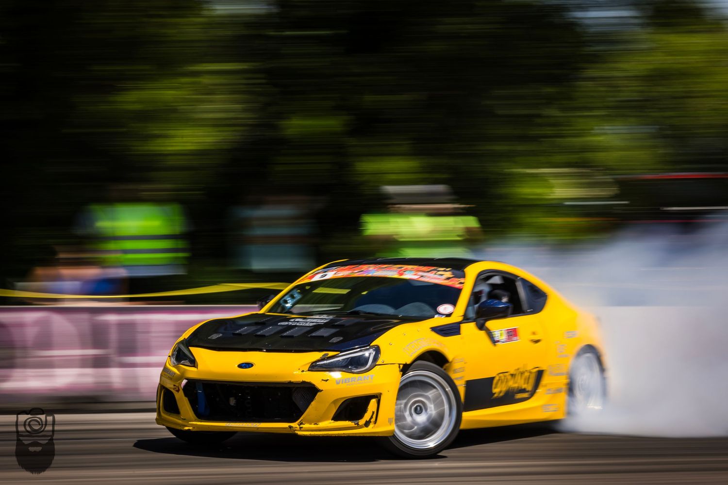 High-performance yellow sports cars drifting on a racetrack.