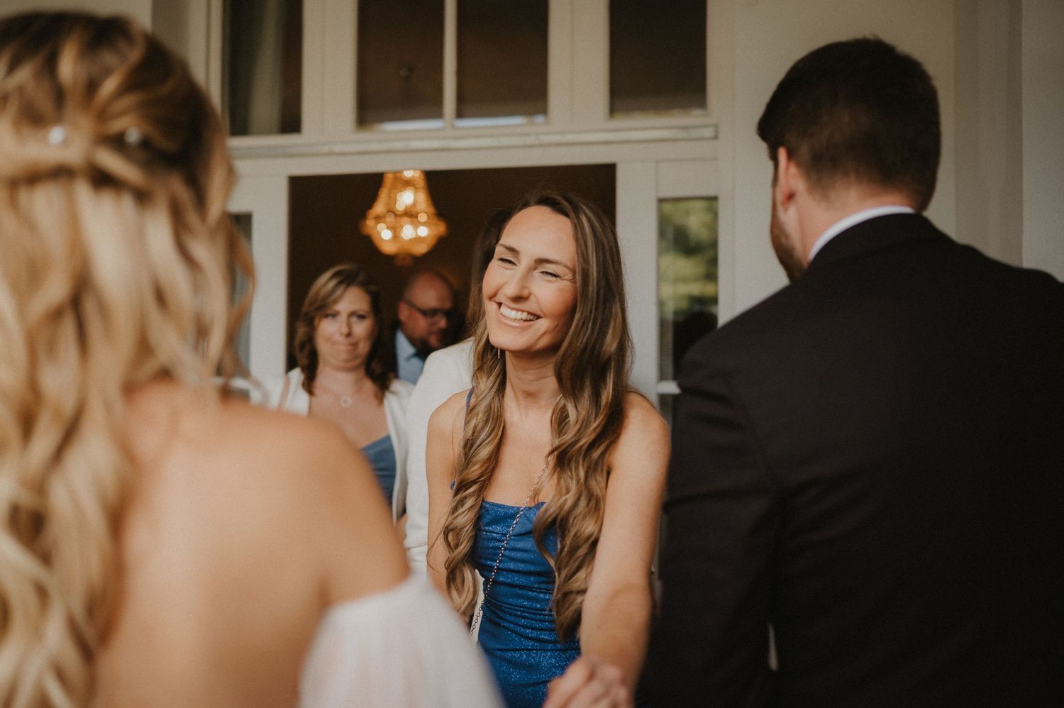 Wedding party members in formal attire gather during celebration.