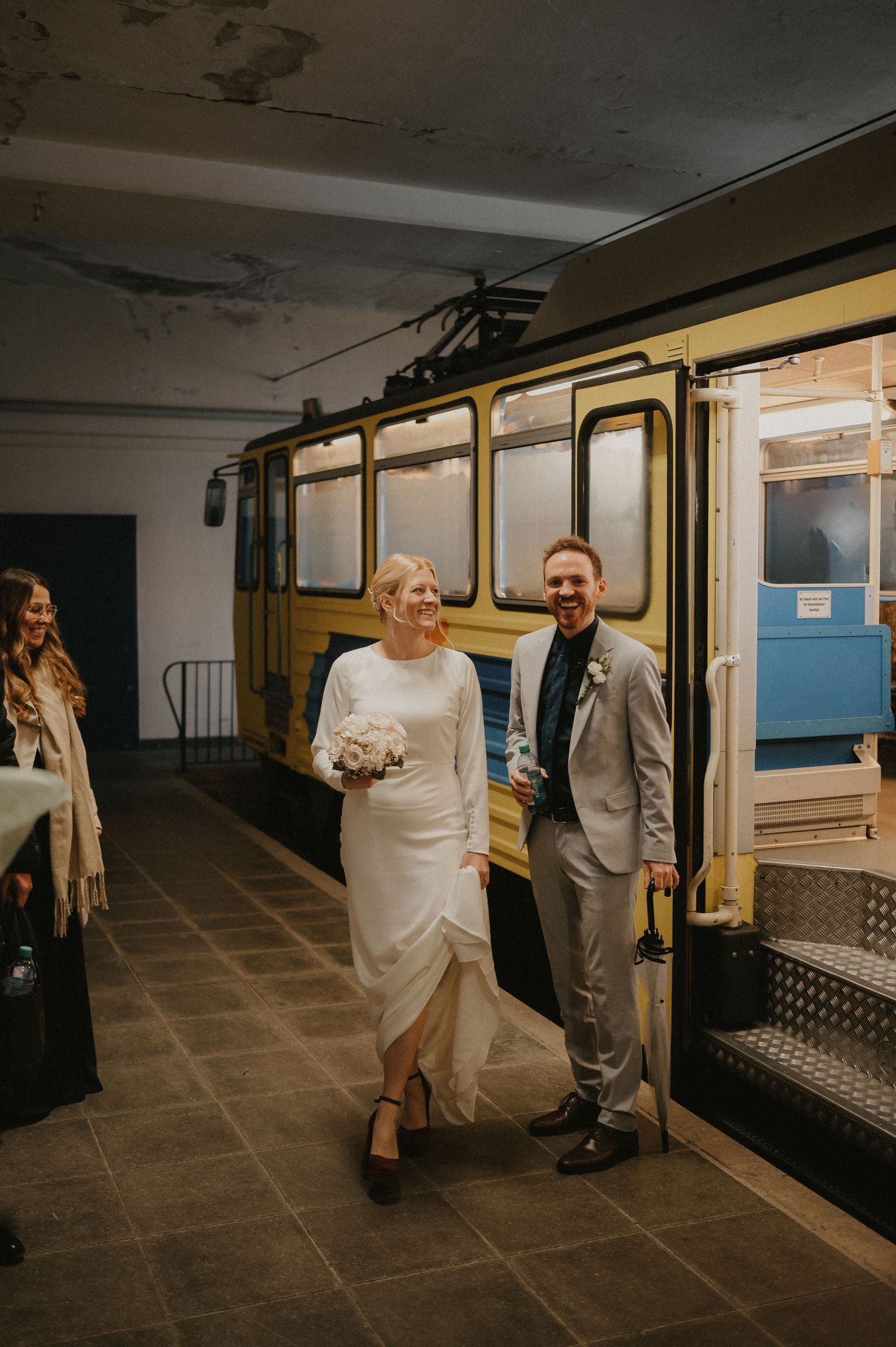 Wedding couple walking through a vintage subway station with dramatic lighting.