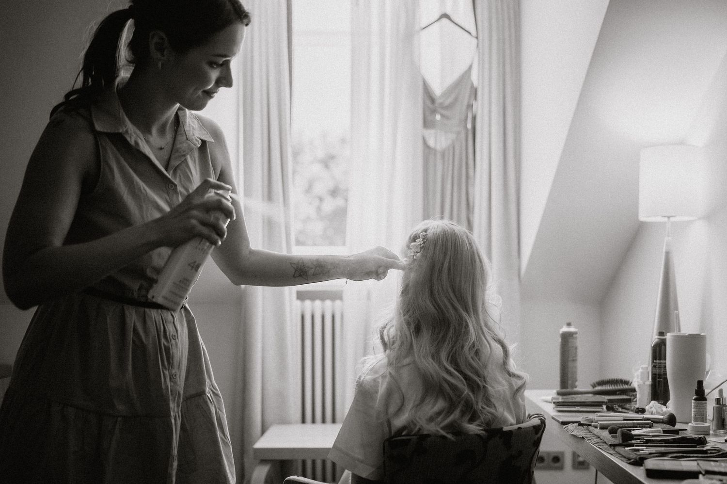 Black and white image of wedding preparation with natural window light.