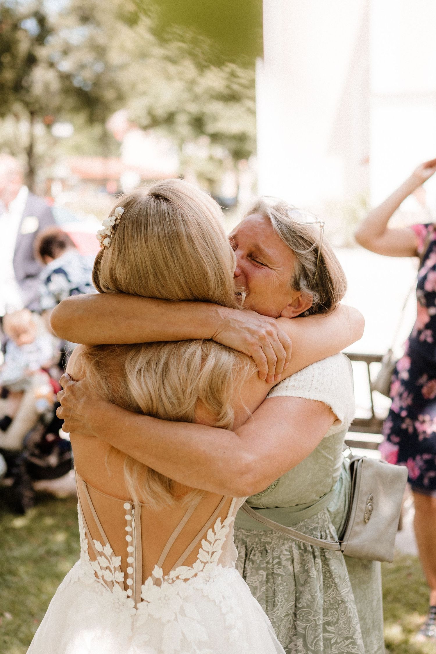 Emotional embrace shared during wedding celebration under white columns.