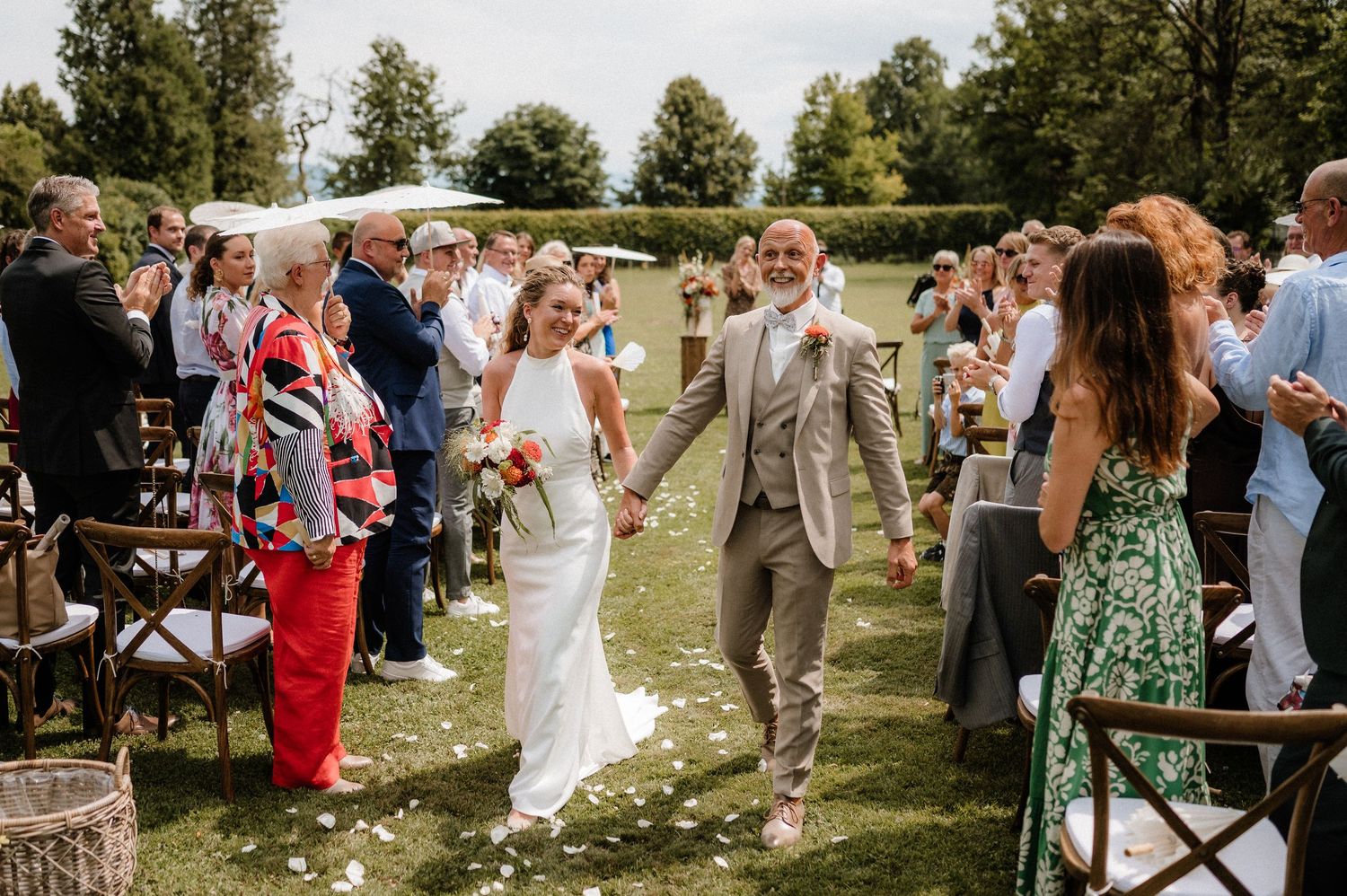Outdoor wedding reception with guests in summer attire enjoying the festivities.