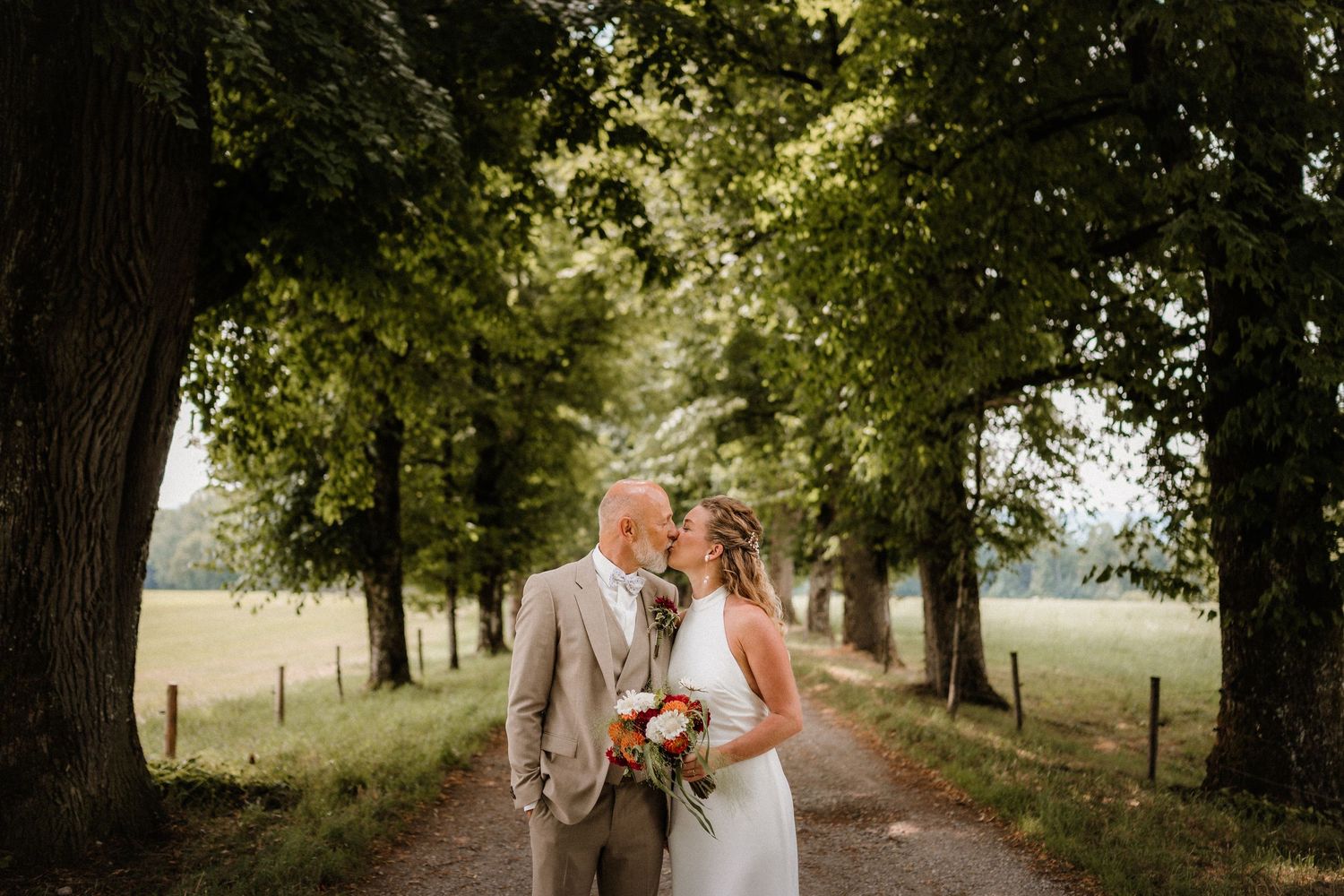 Romantic wedding photos of couple sharing tender moments under a canopy of trees.