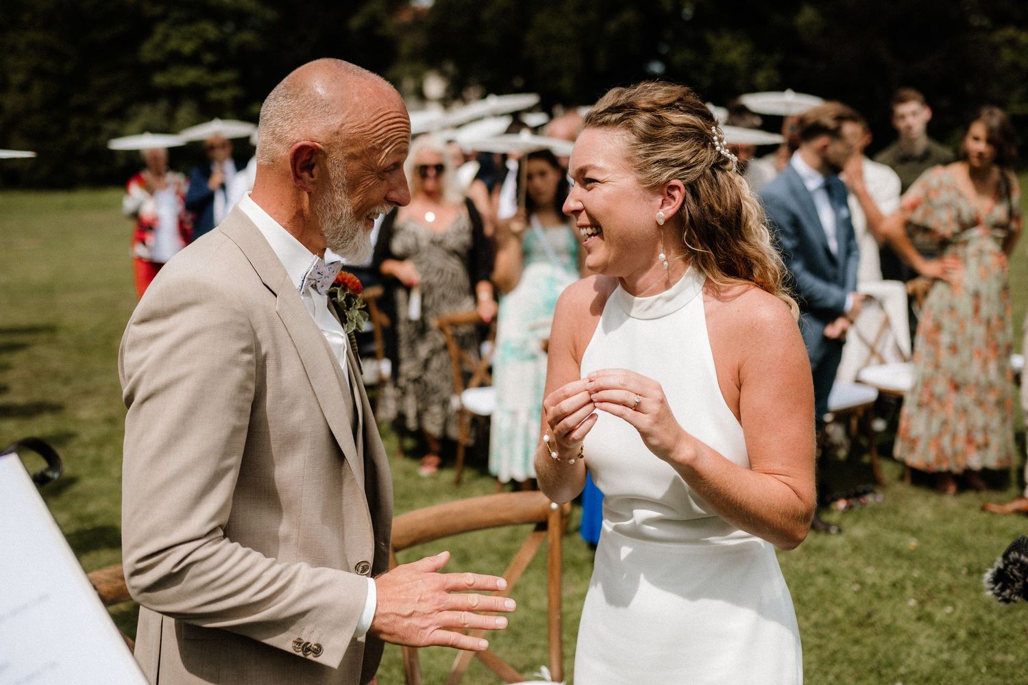 Emotional reactions during a wedding ceremony on a sunny outdoor lawn.