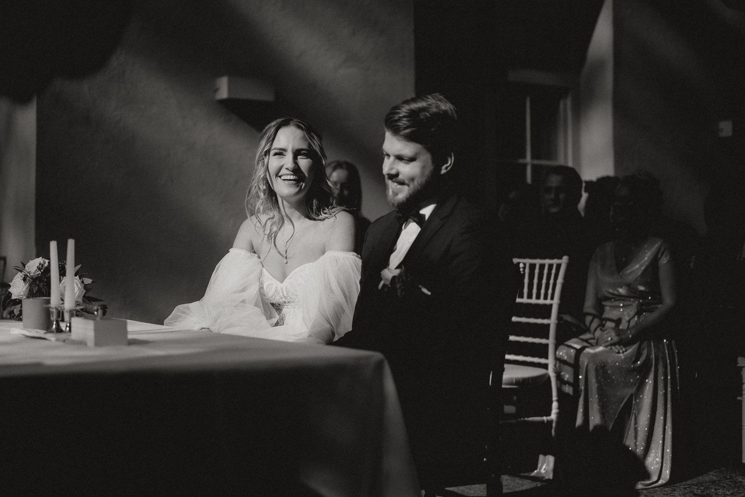 A black and white wedding ceremony photo showing a joyful emotional moment between the couple.