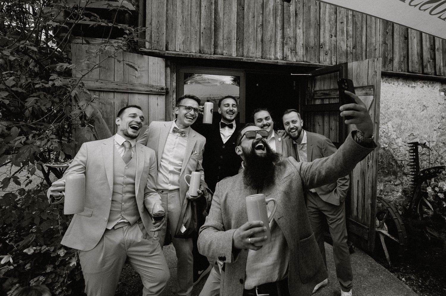 Wedding guests celebrating in an outdoor rustic barn setting.