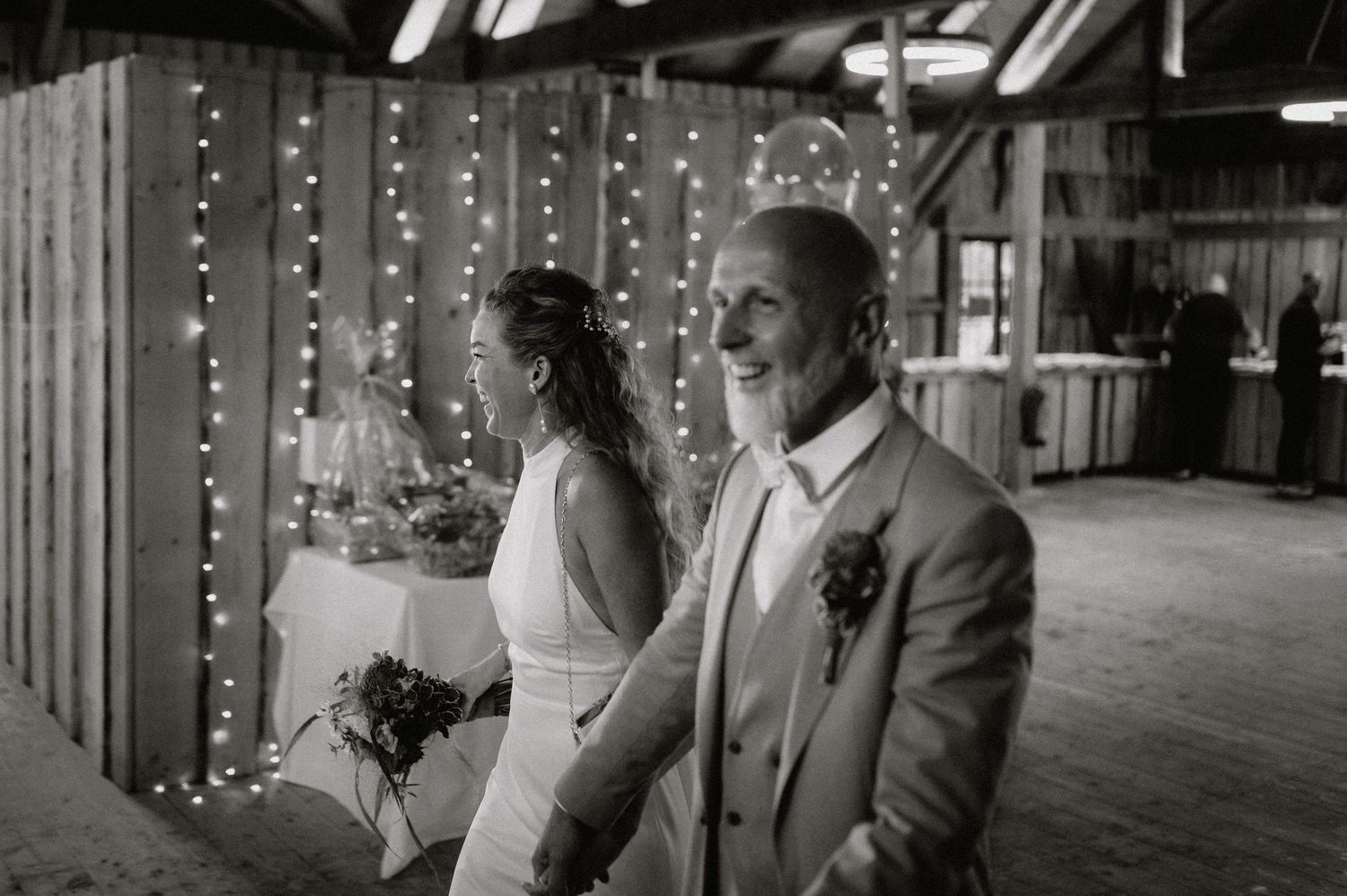 Wedding celebration in a rustic barn venue with string lights and decorative lighting.