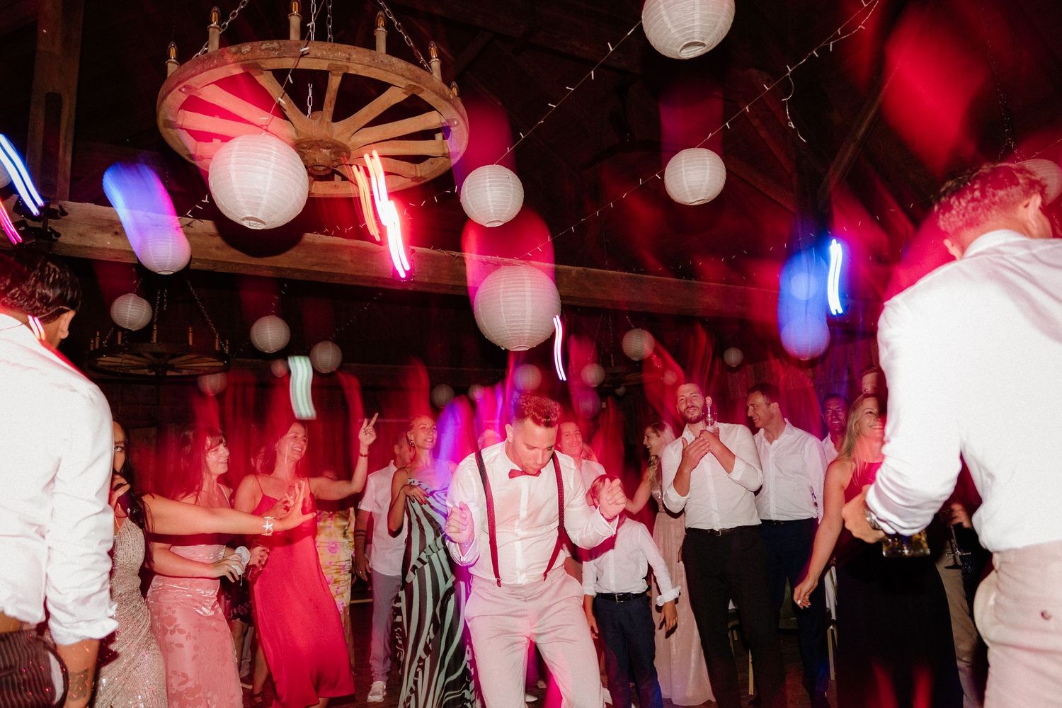 Party venue decorated with paper lanterns and red lighting during a festive celebration.