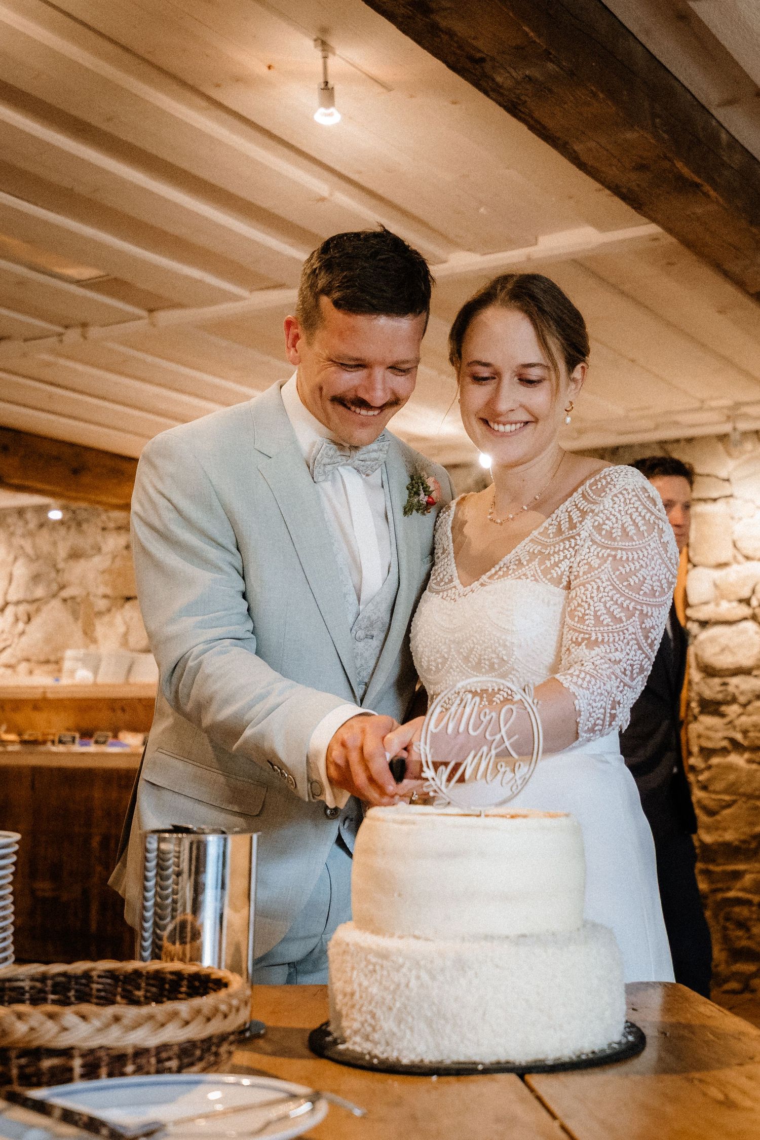 Series of photos showing a couple sharing intimate moments while cutting their white wedding cake.
