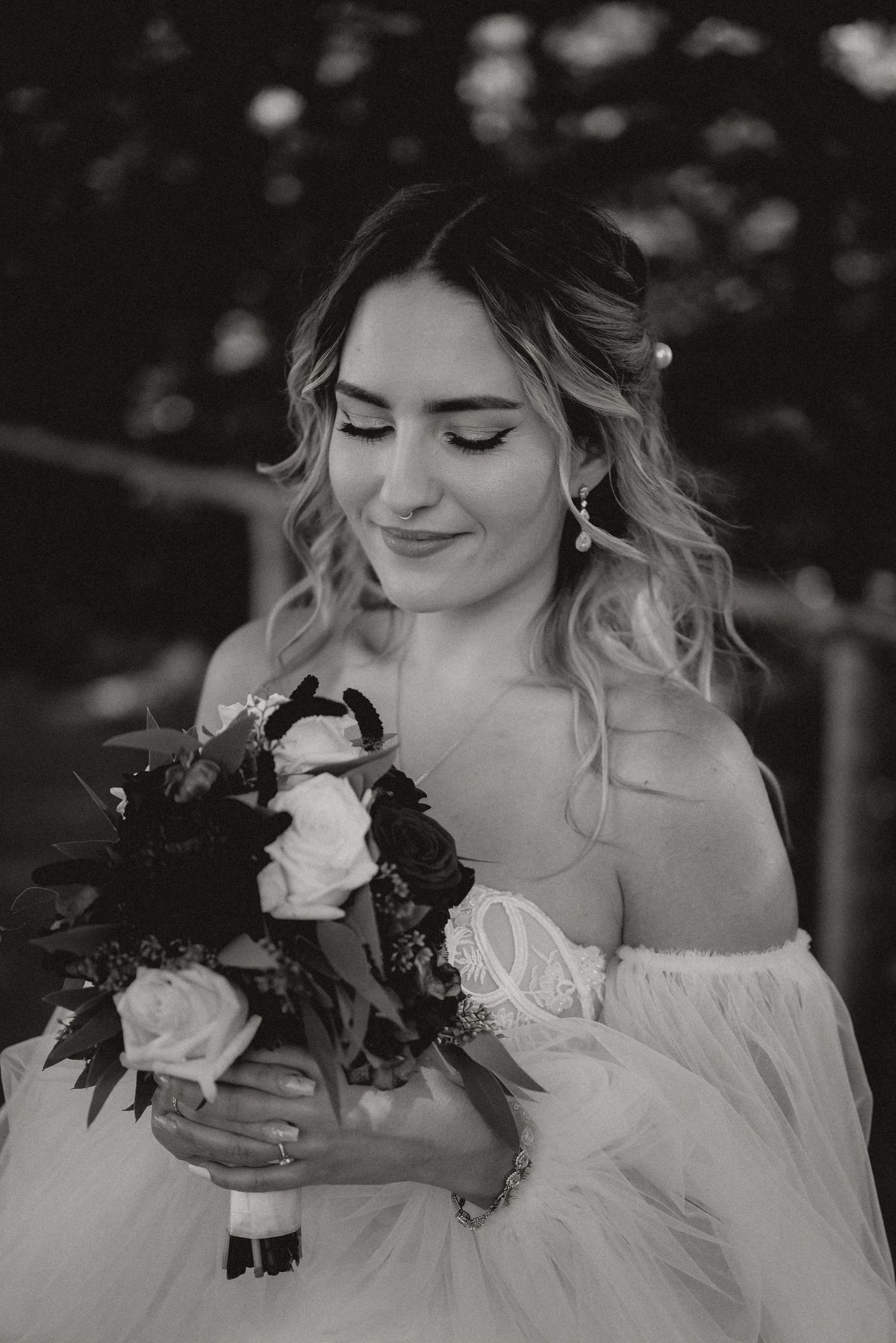Close-up black and white portraits of a bride holding her bouquet with delicate expressions.