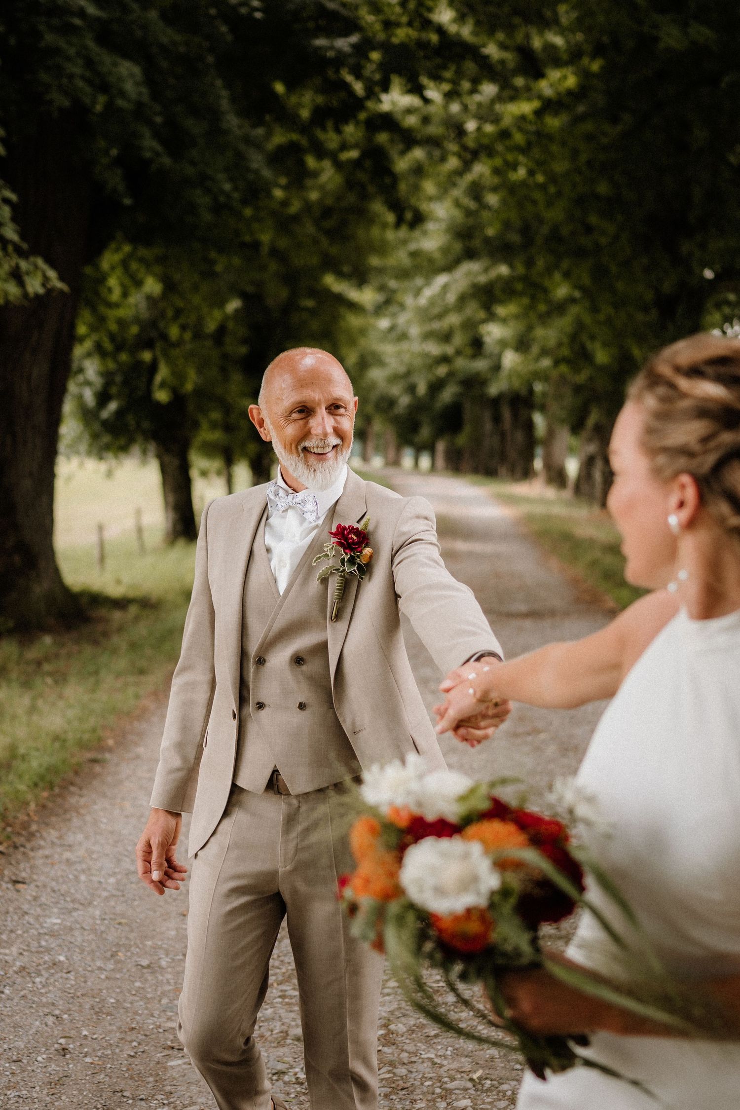 Candid wedding shots showing playful interactions between newlyweds on a tree-lined path.