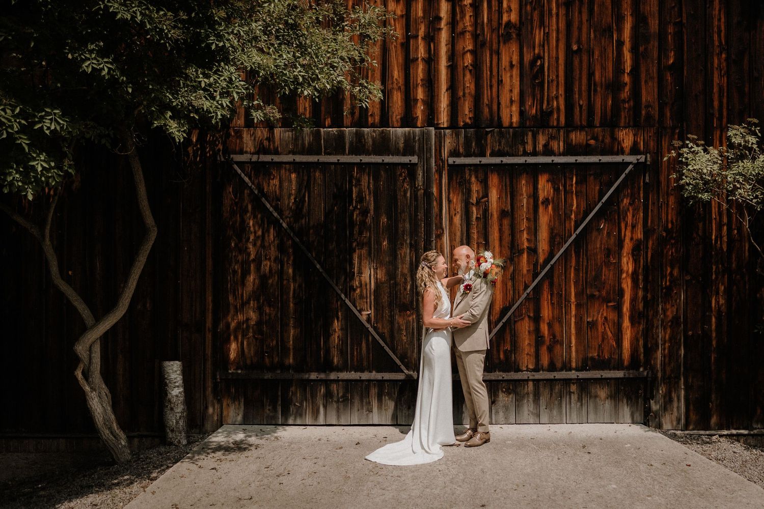 A rustic barn wedding venue with wooden walls creates a charming backdrop.