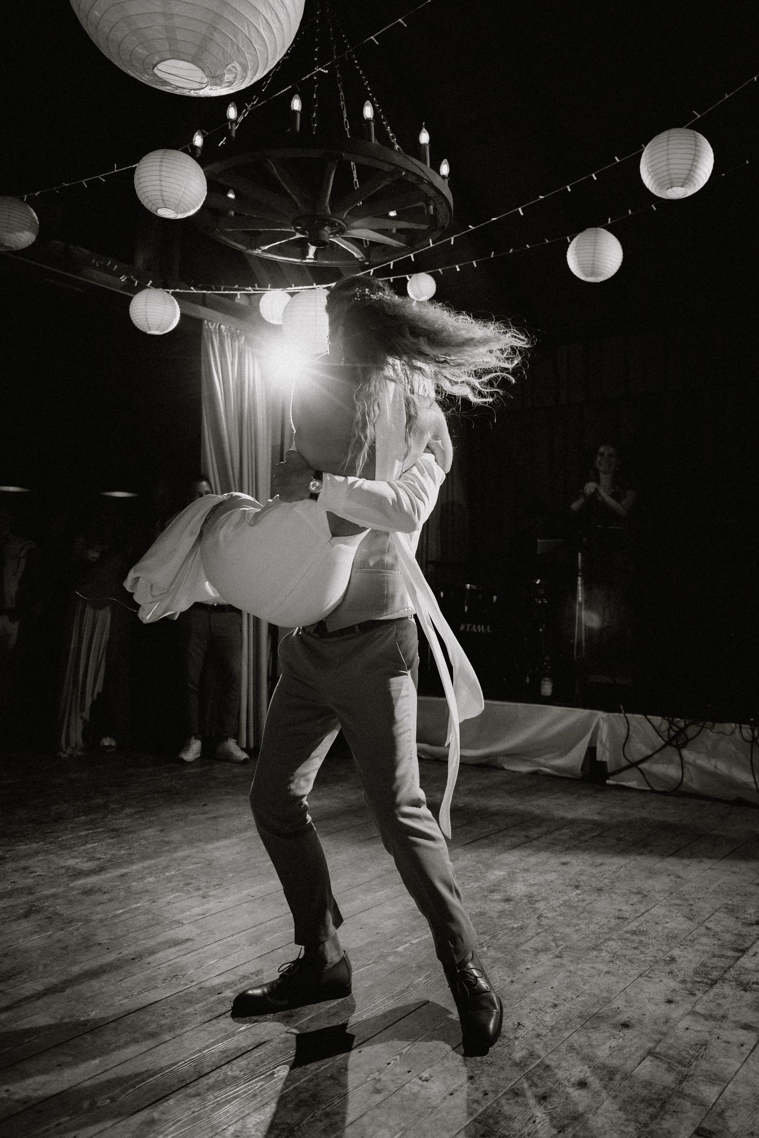 A dramatic dip during a dance performance under paper lanterns in black and white.