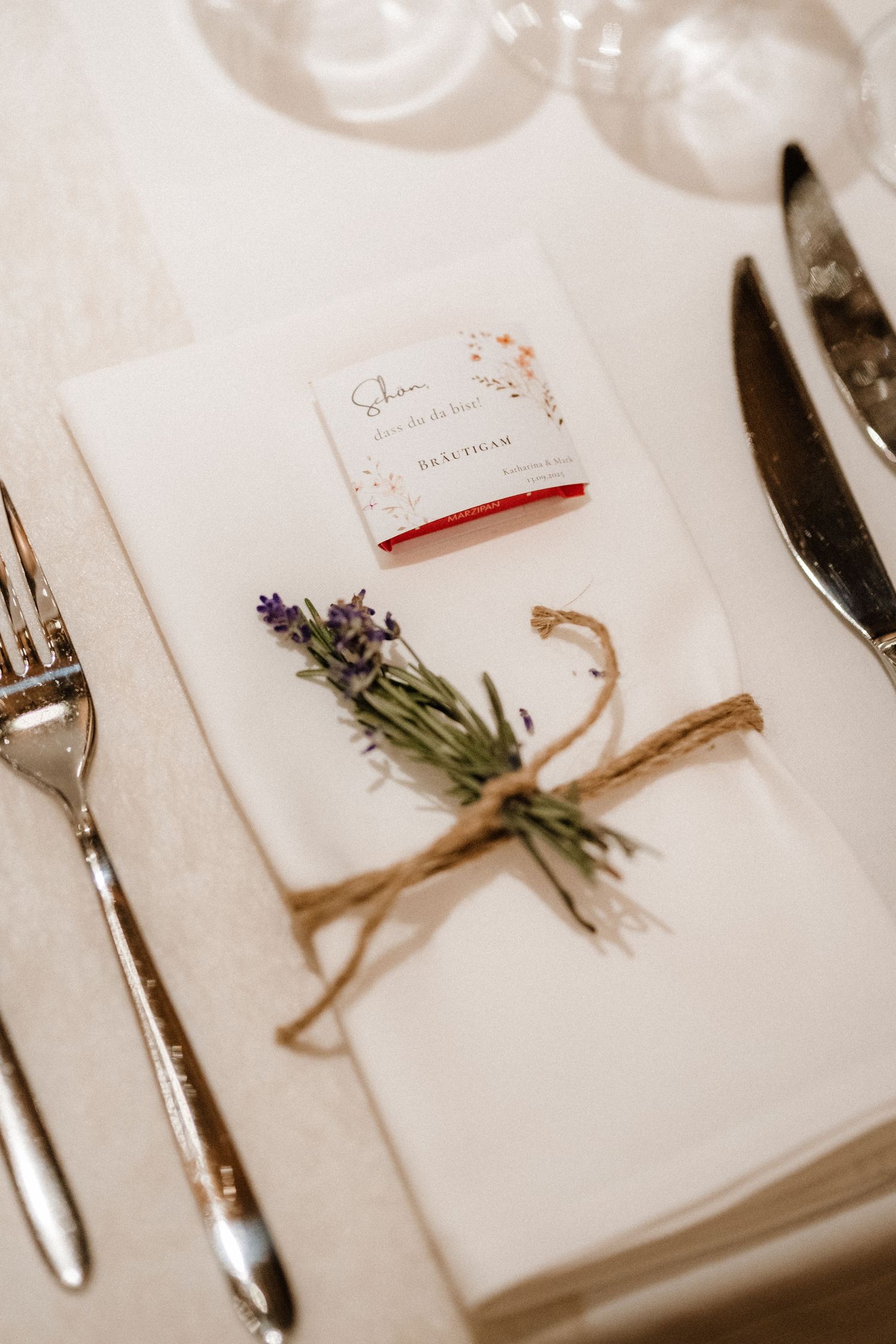 Elegant place settings with lavender sprigs tied with twine on white napkins.