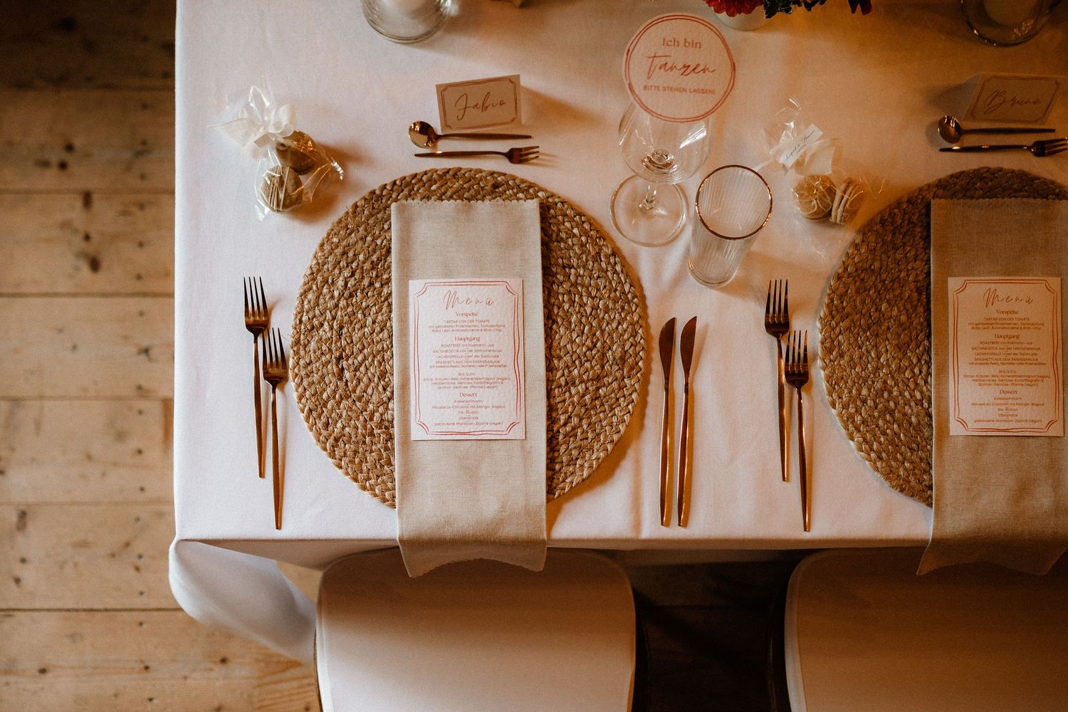 Overhead view of place settings with woven placemats and elegant tableware.