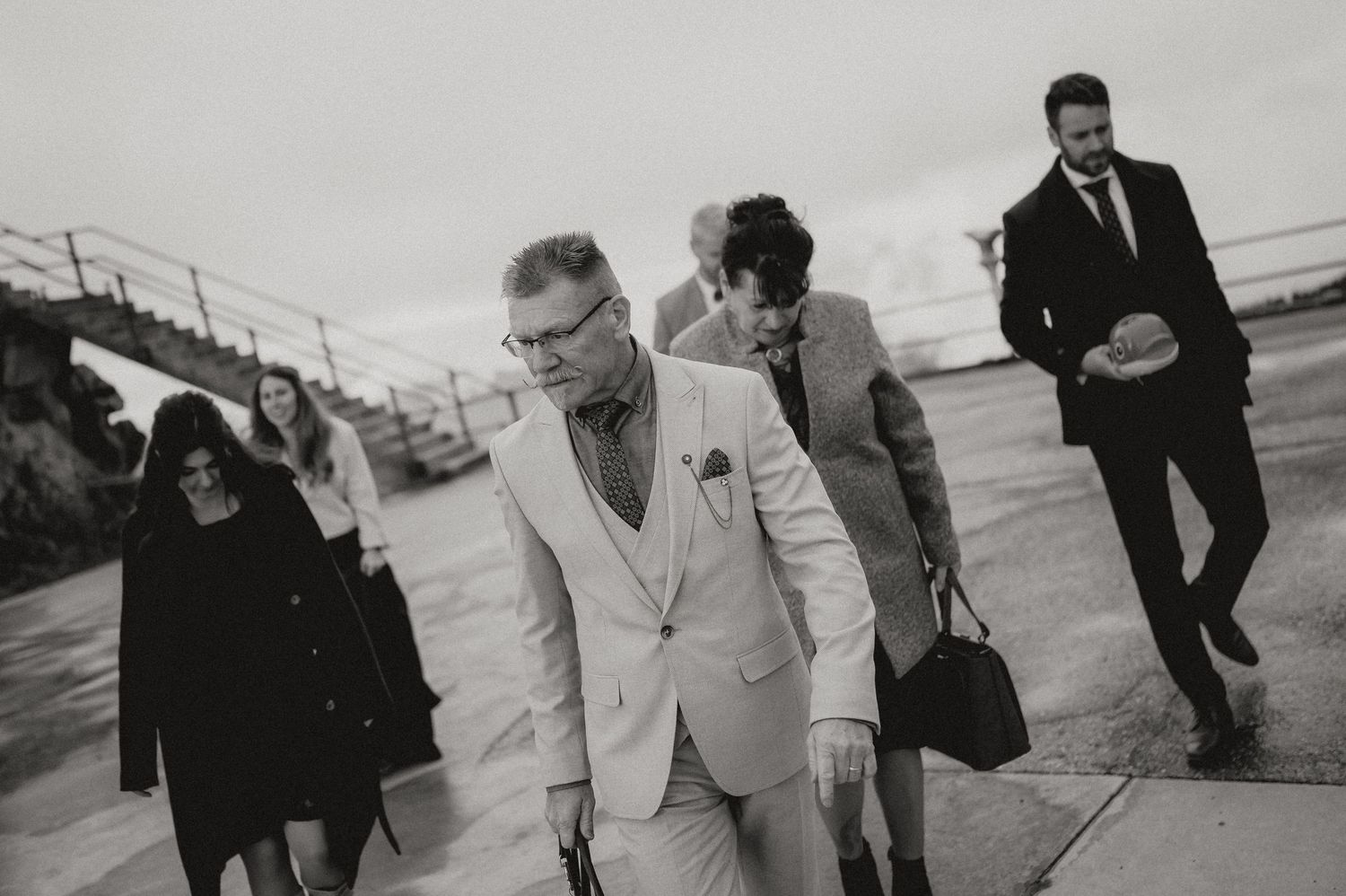 Wedding guests walk along an outdoor pathway during the celebration.