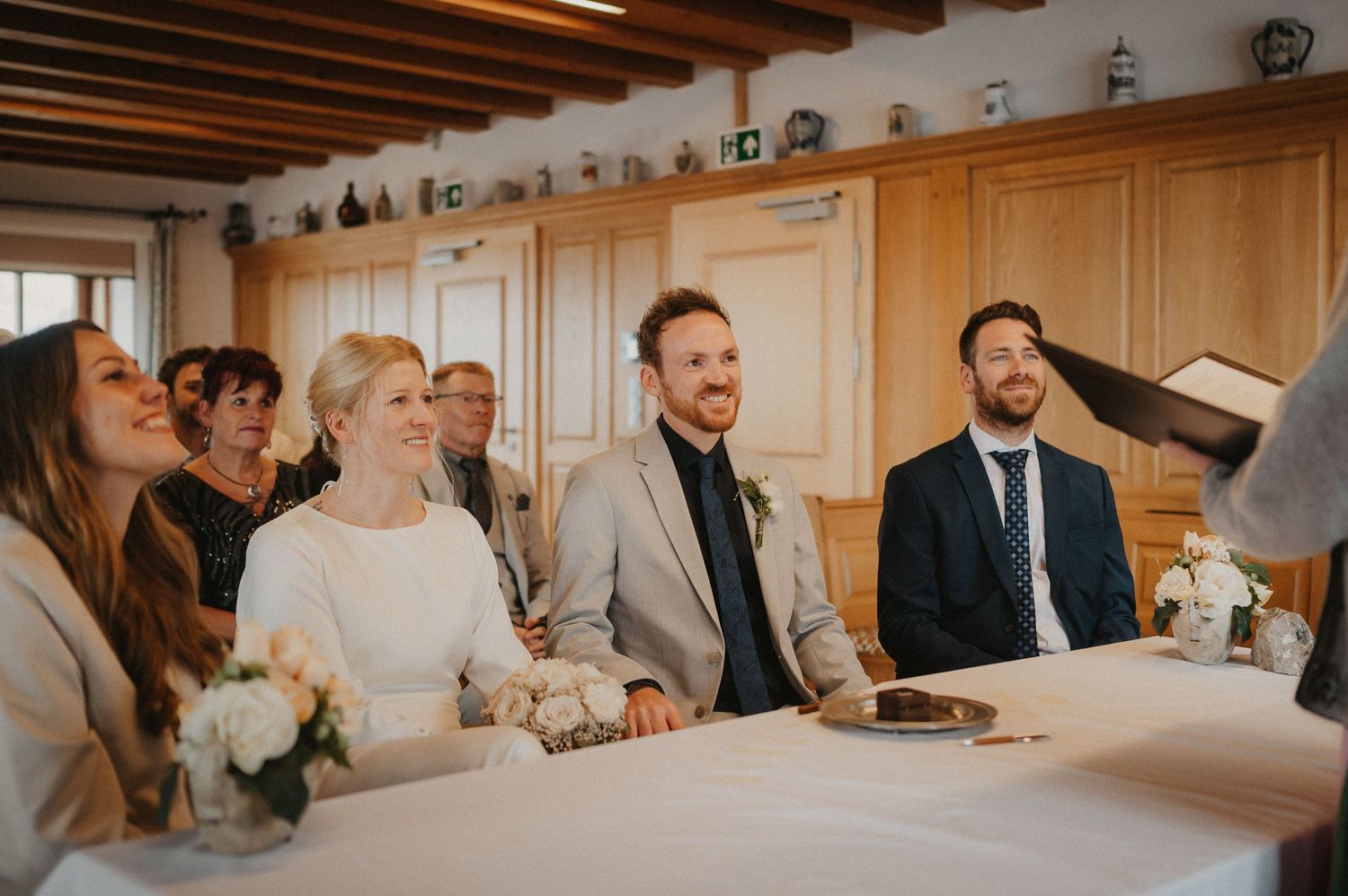 Wedding celebration in a rustic venue with exposed wooden beams and elegant wall paneling.