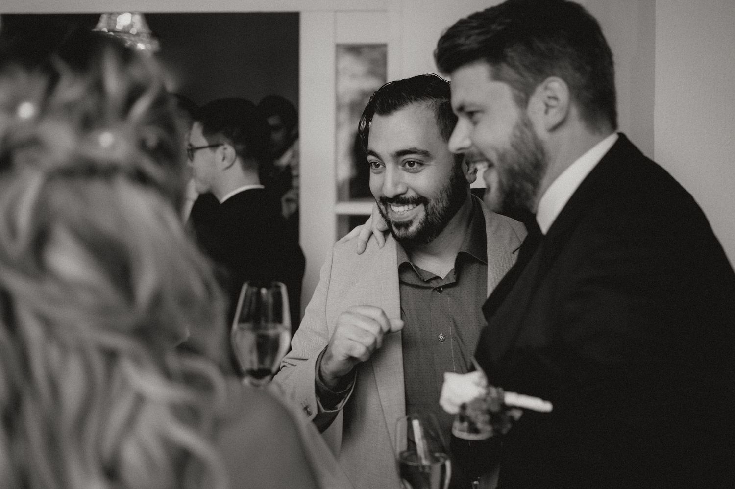 Candid black and white shots of wedding reception interactions.