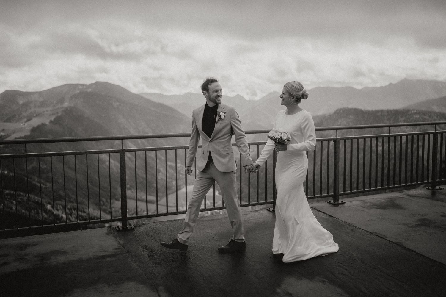 Couple and guests enjoy scenic mountain views from an observation deck.