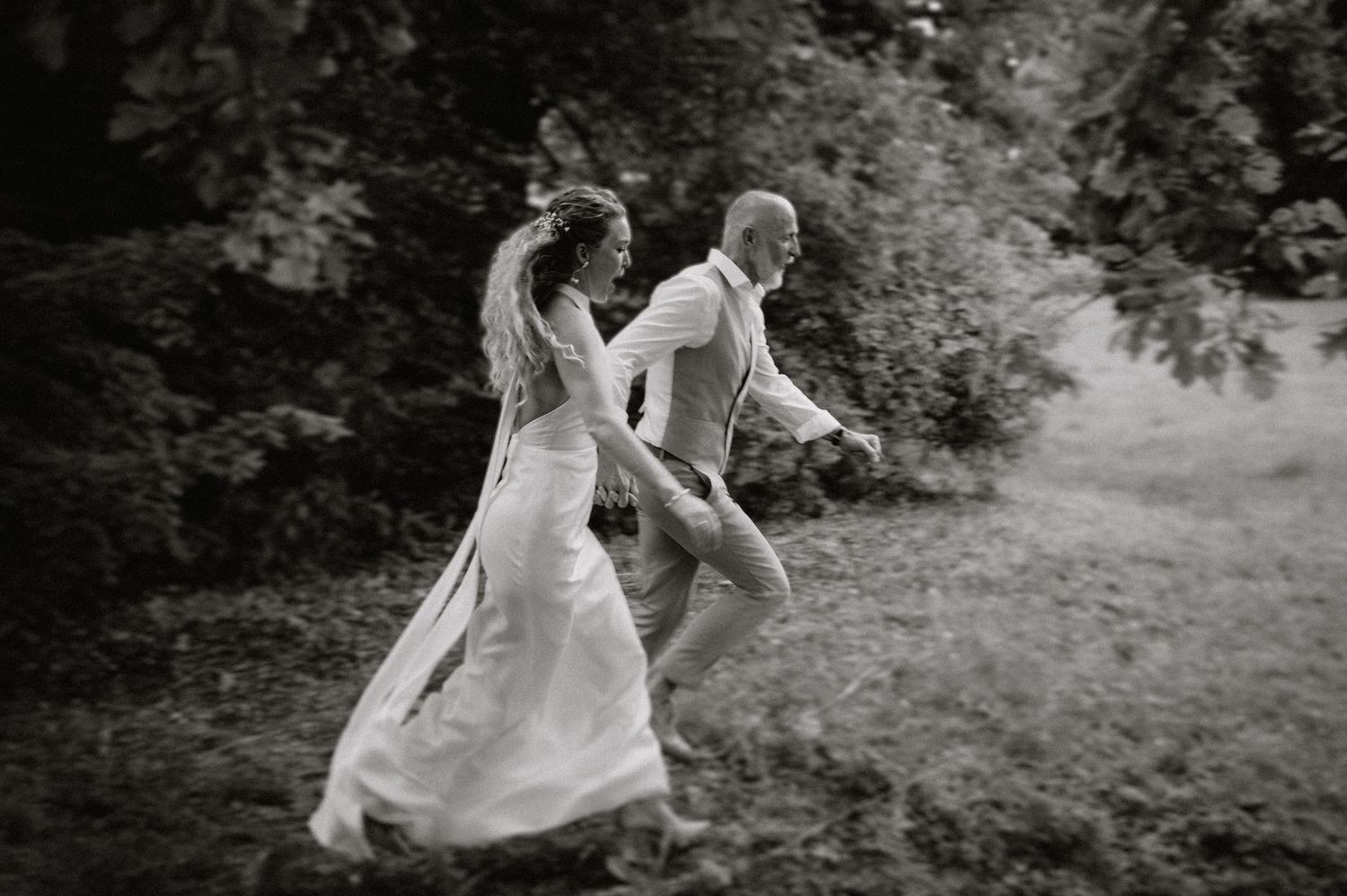 A playful dance sequence captured in black and white on a grassy field.