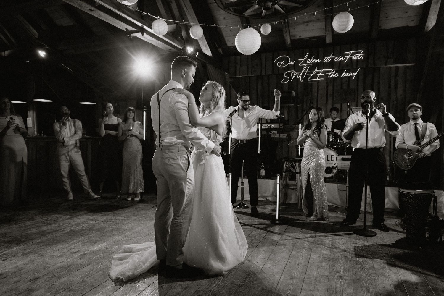 Schwarz-Weiß-Foto von Paaren, die bei einem eleganten Hochzeitsempfang mit Papierlaternendekorationen tanzen. Von Dama Fotografie Bad Tölz