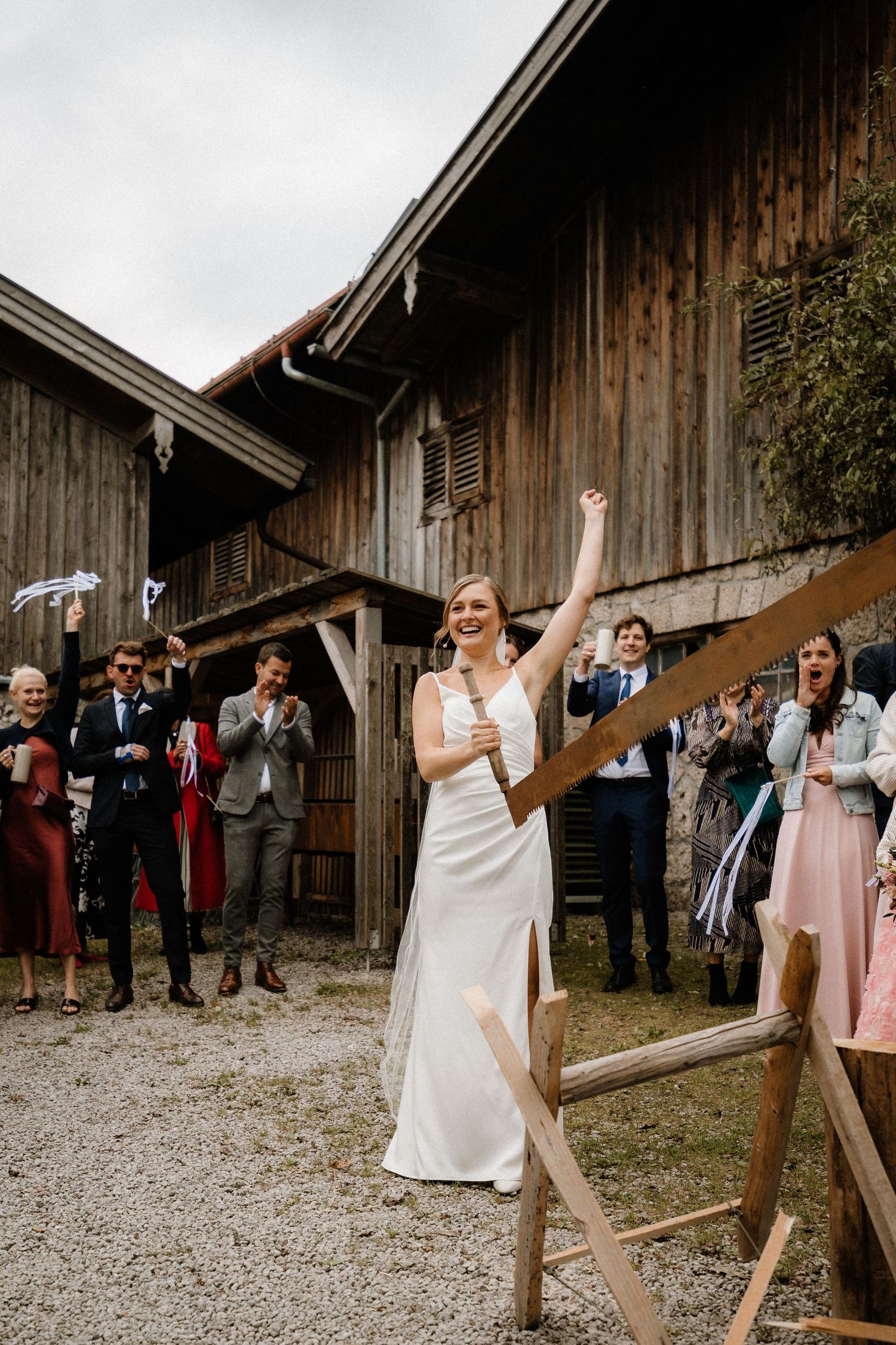 Joyful celebration at rustic barn wedding with guests watching outdoor ceremony.