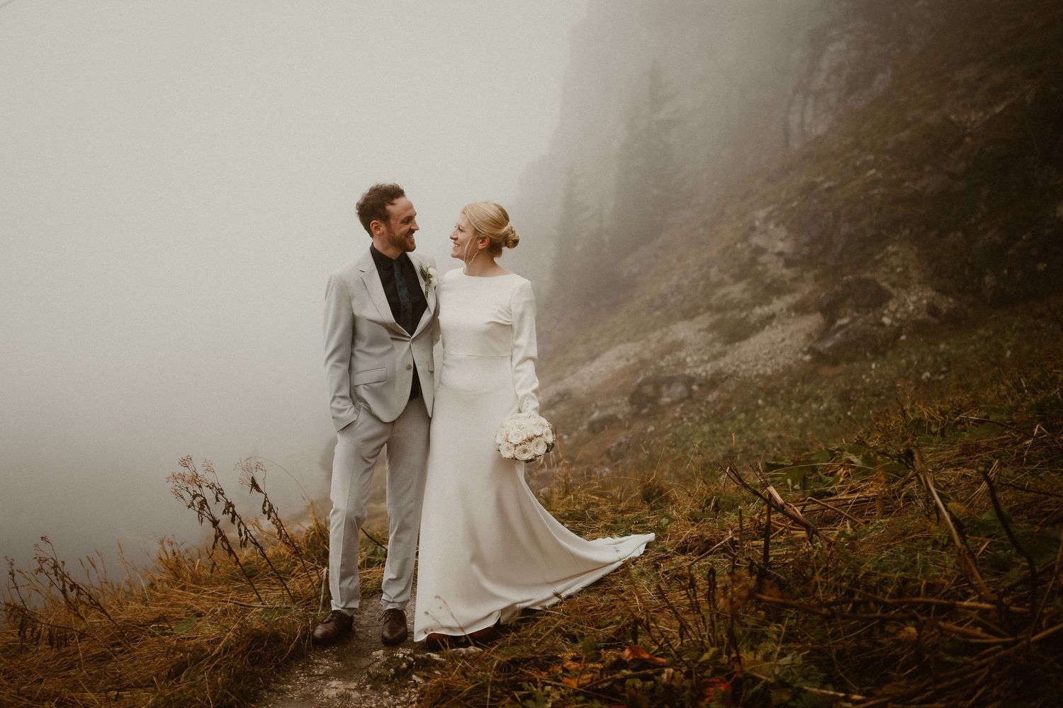 Braut und Bräutigam teilen intime Momente während ihres Fotoshootings für die Berghochzeit. Von Dama Fotografie Bad Tölz