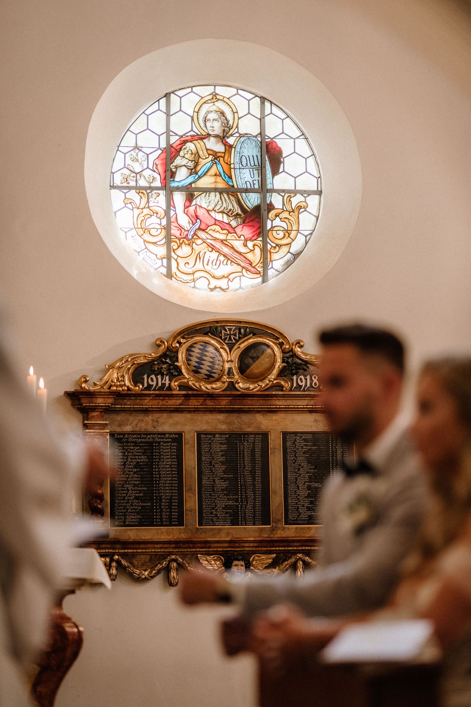 Ornate stained glass windows and decorative wooden panels inside a historic church sanctuary.