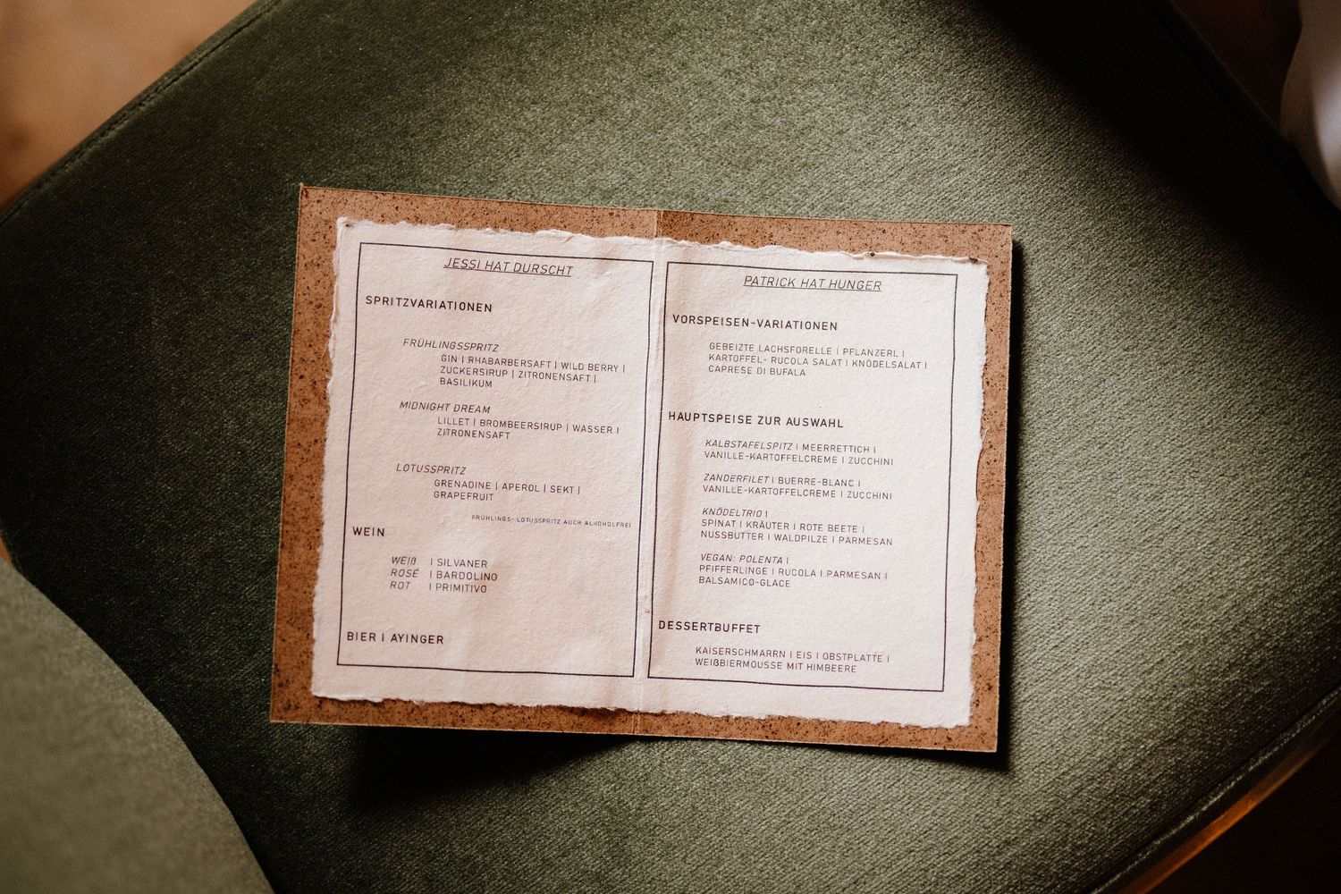 Wedding menu cards with brown borders photographed in dramatic lighting.