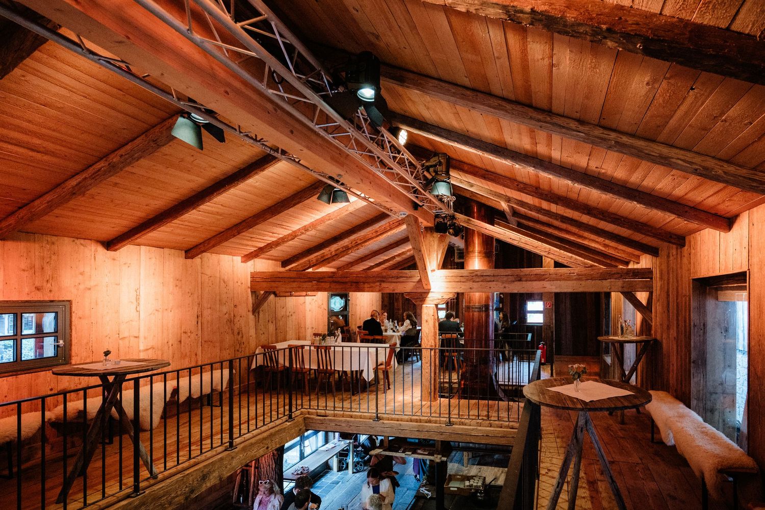 Rustic wooden barn interior with exposed beams and warm lighting creating an intimate atmosphere.