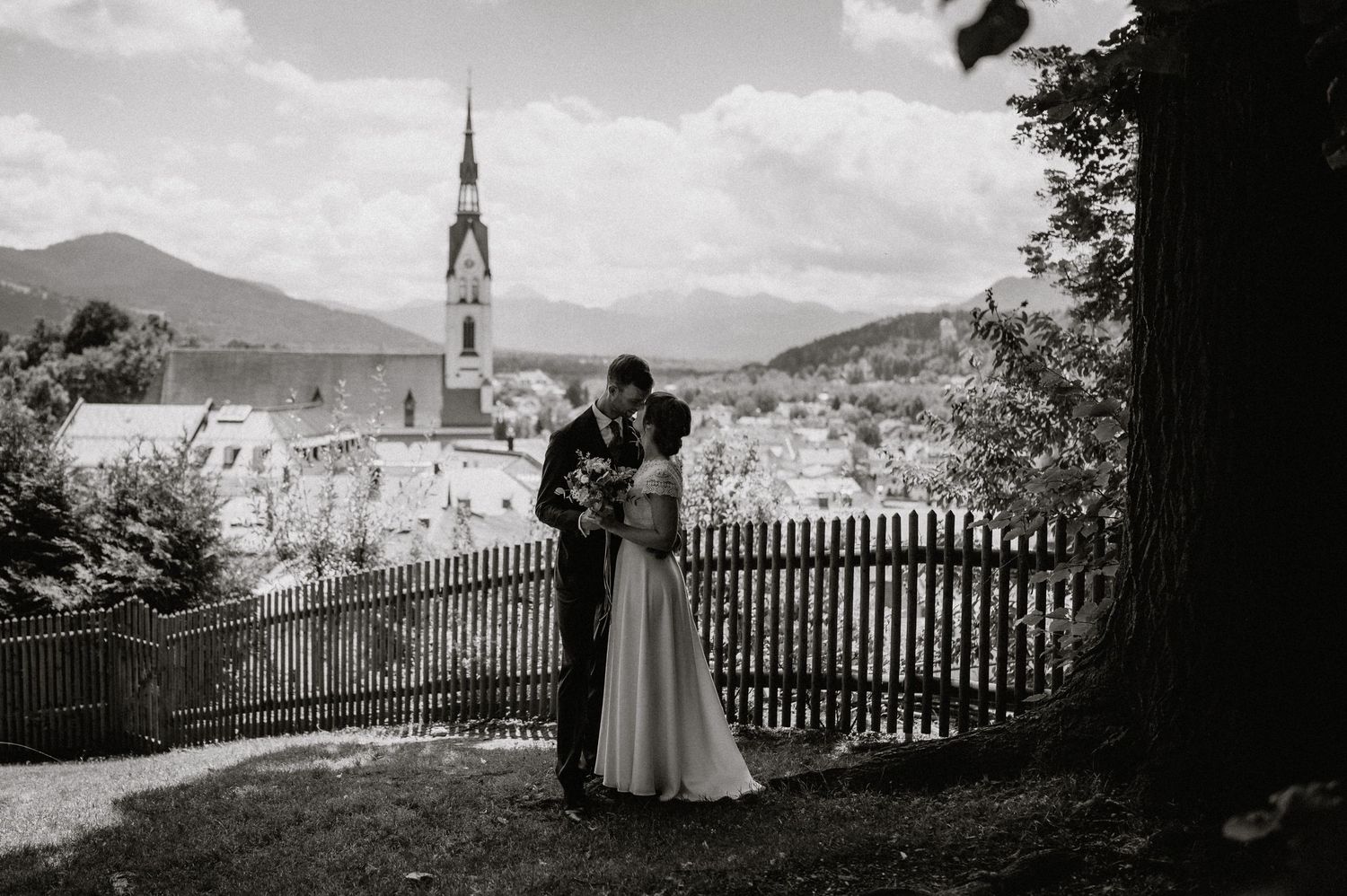 Ein romantischer schwarz-weißer Panoramablick auf ein Bad Tölz mit einem Kirchen Turm in einem Bergtal. Von Dama Fotografie Bad Tölz