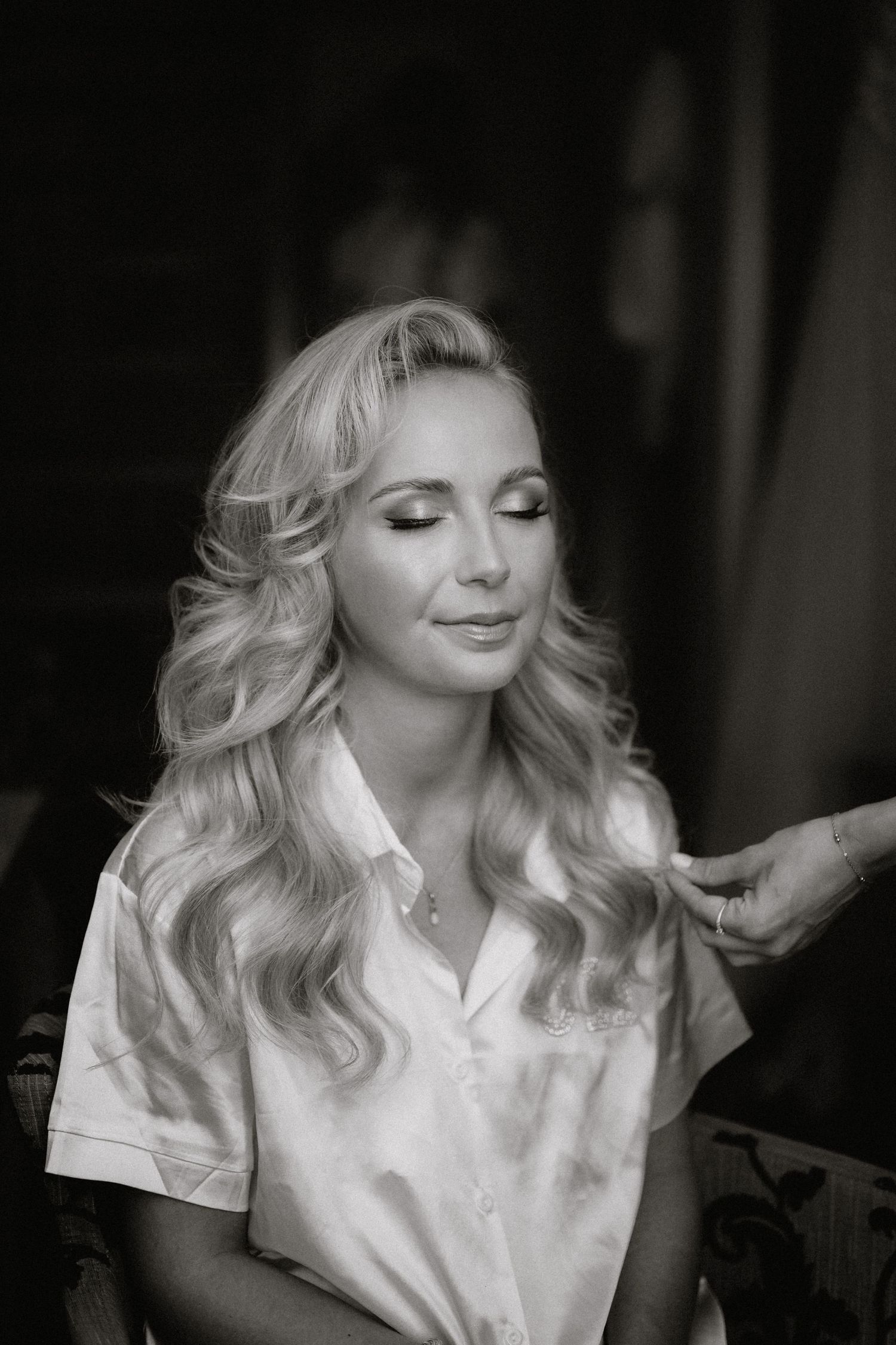 Black and white photos show a woman getting ready in a white robe with styled blonde waves.