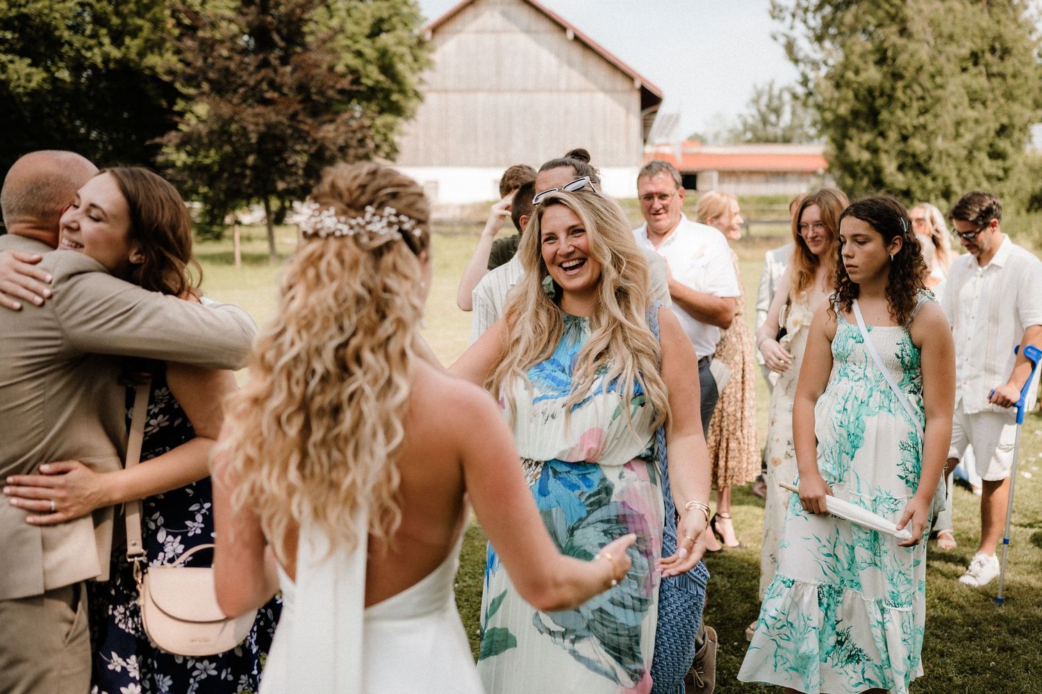 Wedding party members in matching turquoise dresses celebrate joyfully outdoors.