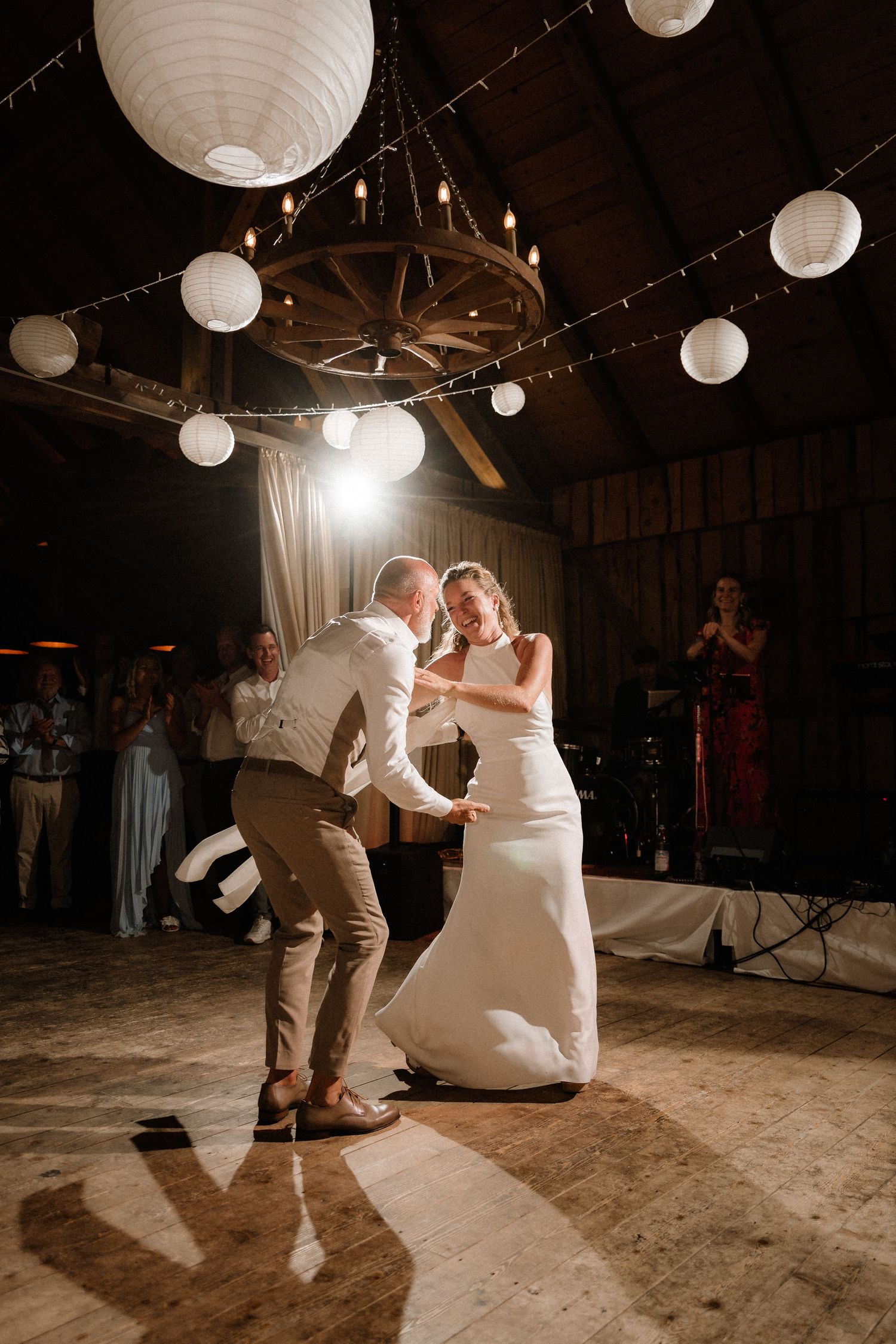 An energetic dance move captured during a barn wedding reception.