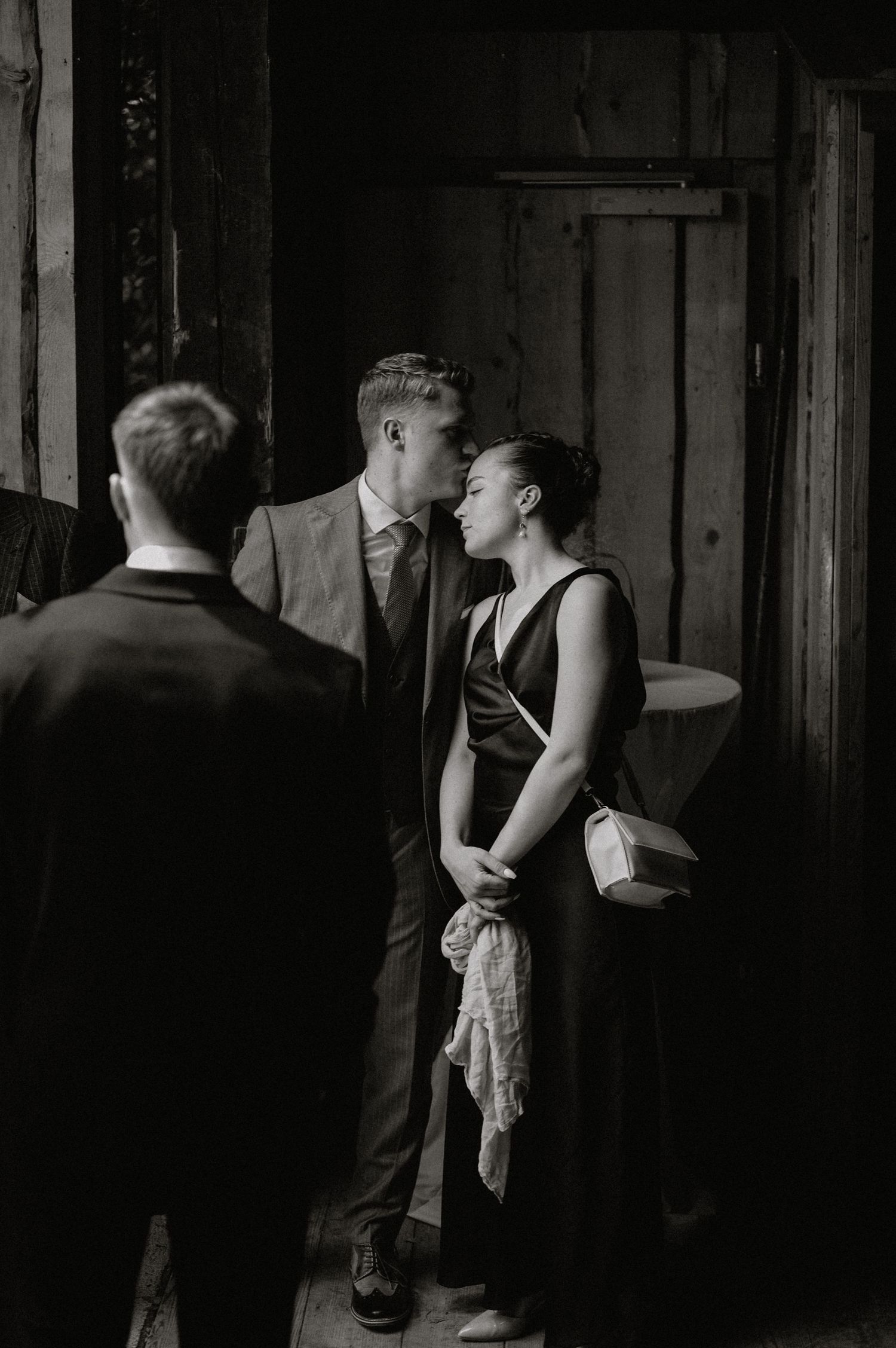 Artistic black and white photo of guests mingling at a wedding reception.