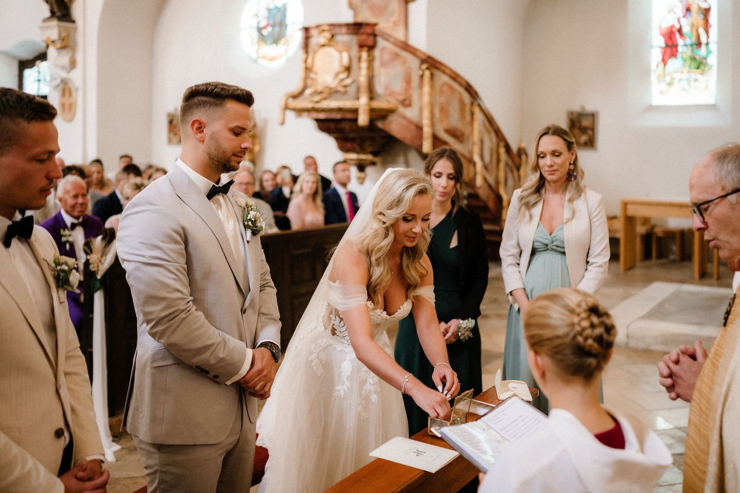 Wedding party sharing emotional moments during a church ceremony with elegant decor.