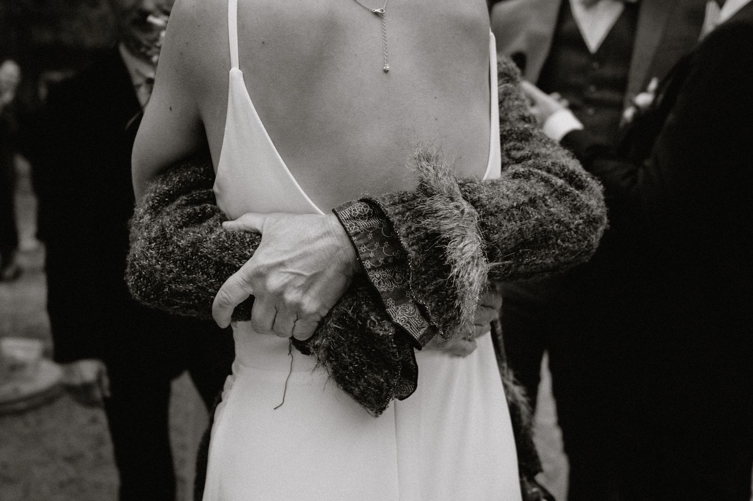 Black and white photo of wedding guests participating in traditional ceremony.